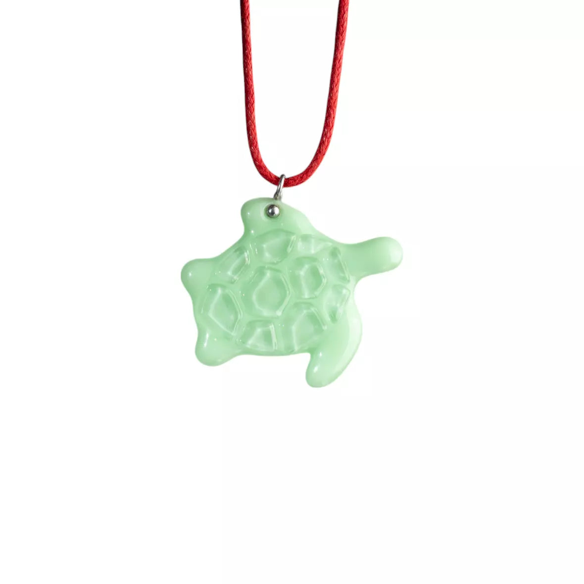 Mint turtle stained glass necklace on a red cord against a white background