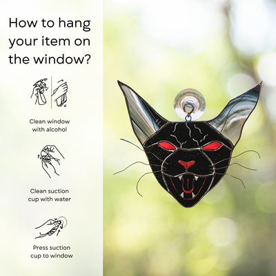 Stained glass black cat with red eyes and fangs, hanging instructions beside: clean window and suction cup, press a cup to the surface.