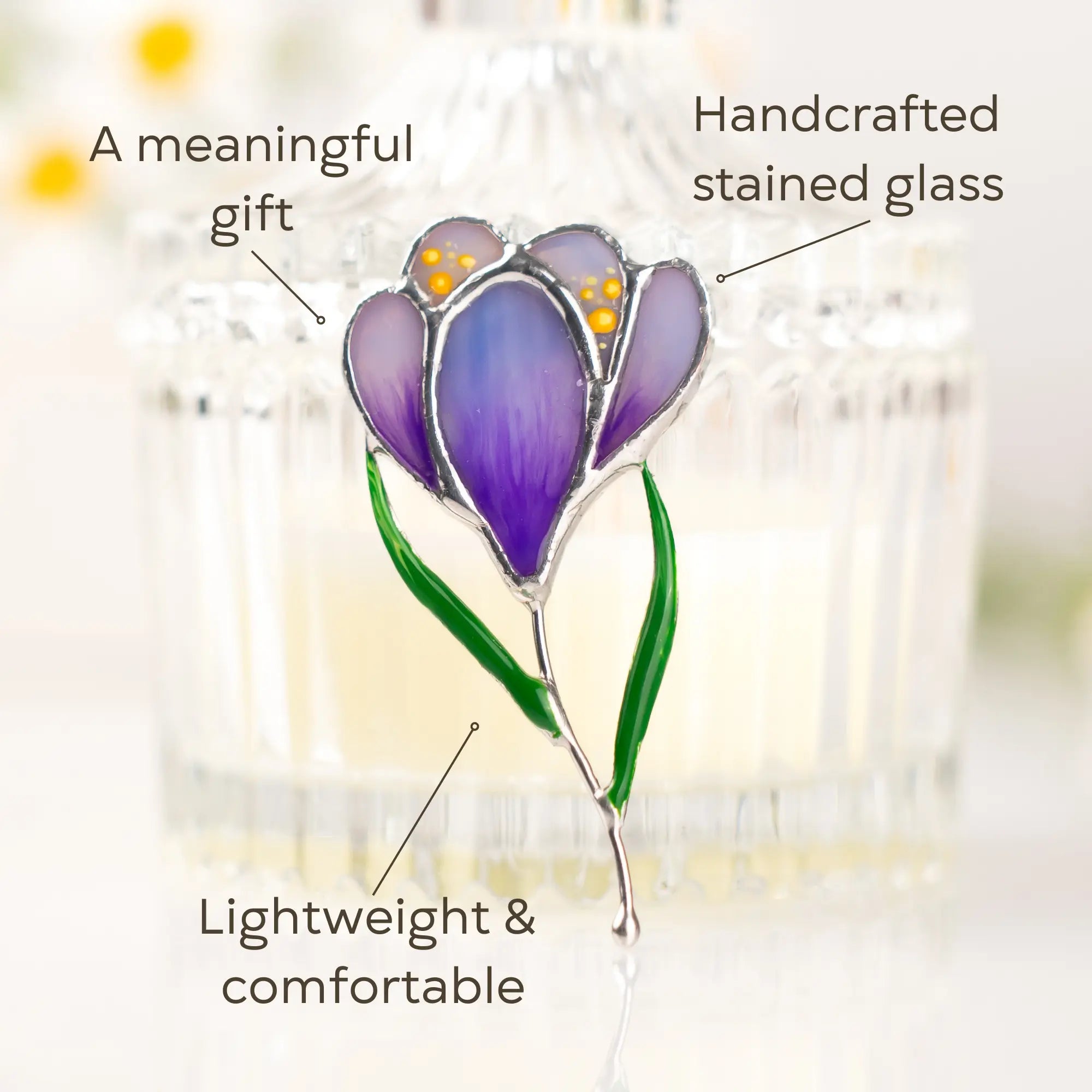 Purple stained glass crocus brooch shown with infographic highlighting handcrafted design, lightweight feel, and gift suitability.