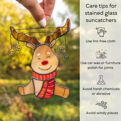 Close-up of stained glass reindeer held by hand outdoors, with care tips shown beside the image: use lint-free cloth, polish joints with car wax or furniture polish, avoid harsh chemicals, and windy places.
