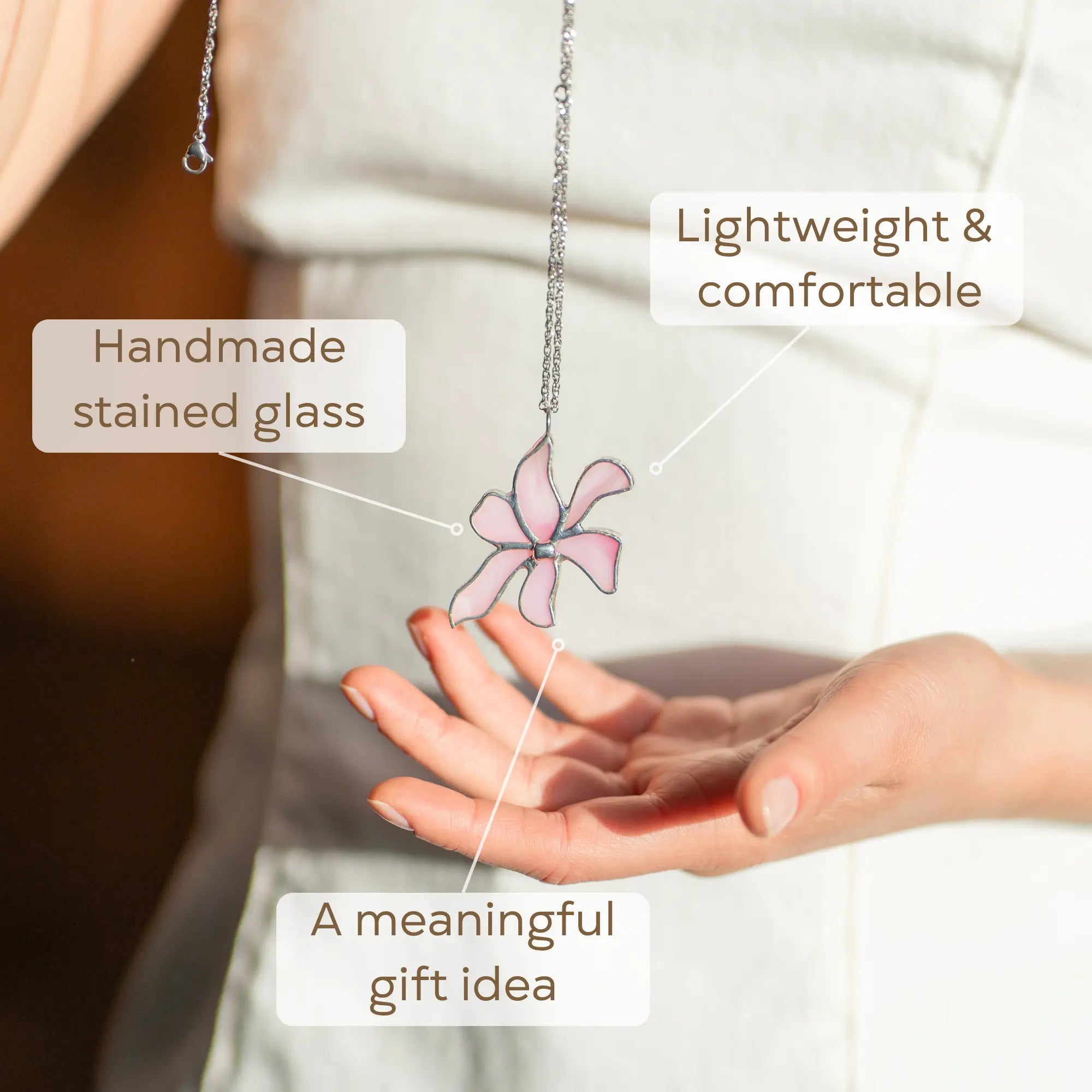Handmade stained glass necklace with butterfly pendant held in a hand, a meaningful gift idea
