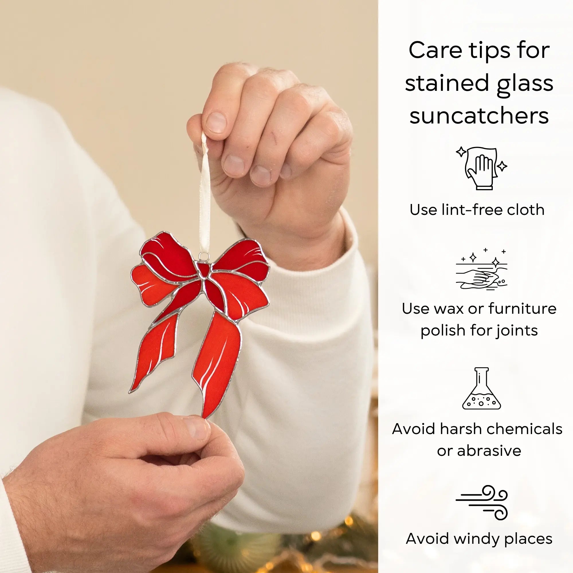 Person holding a red stained glass suncatcher with care tips on the right side: use lint-free cloth, polish joints with car wax or furniture polish, avoid harsh chemicals, and windy places.