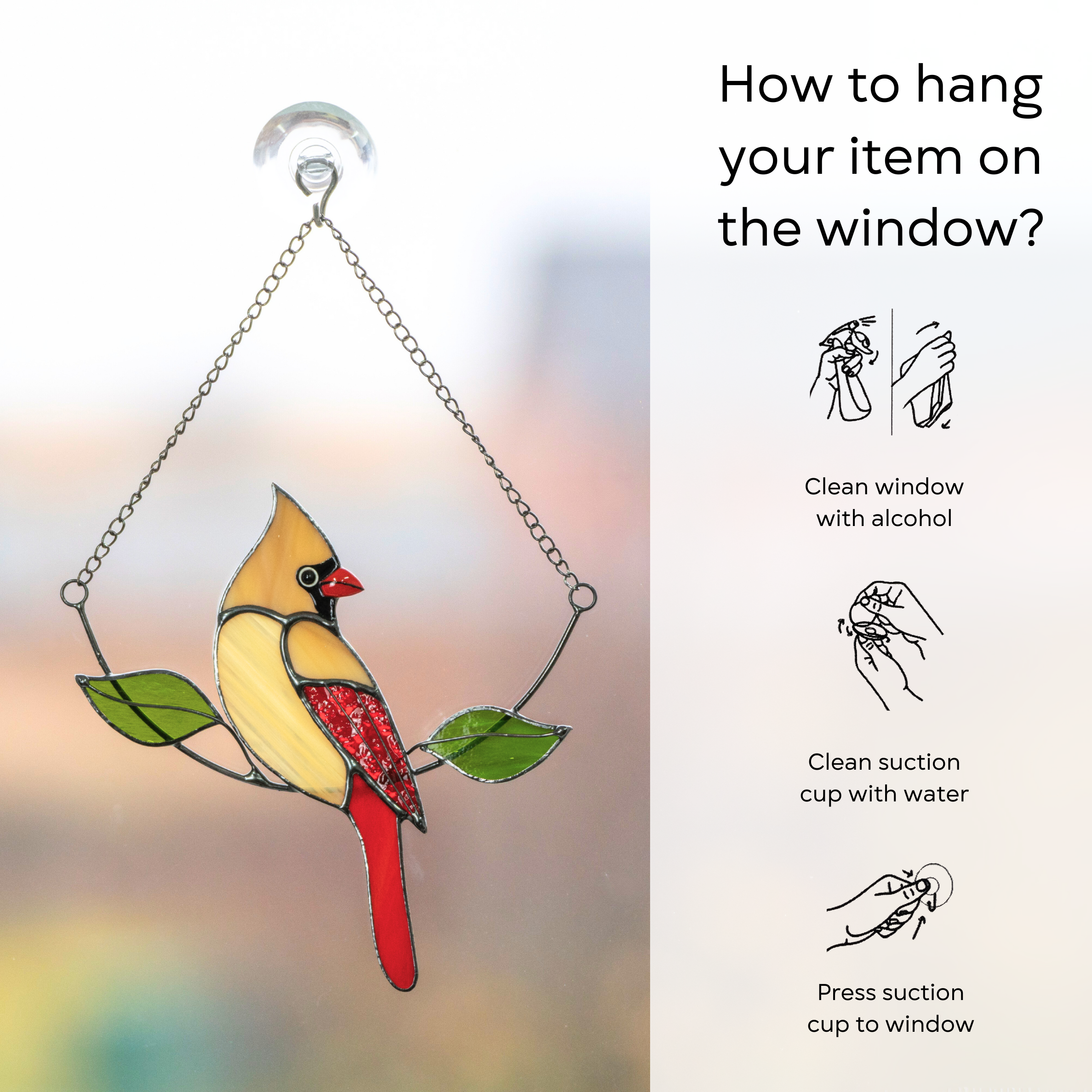 Female cardinal suncatcher on a window attached with suction cup, hanging from a metal chain
