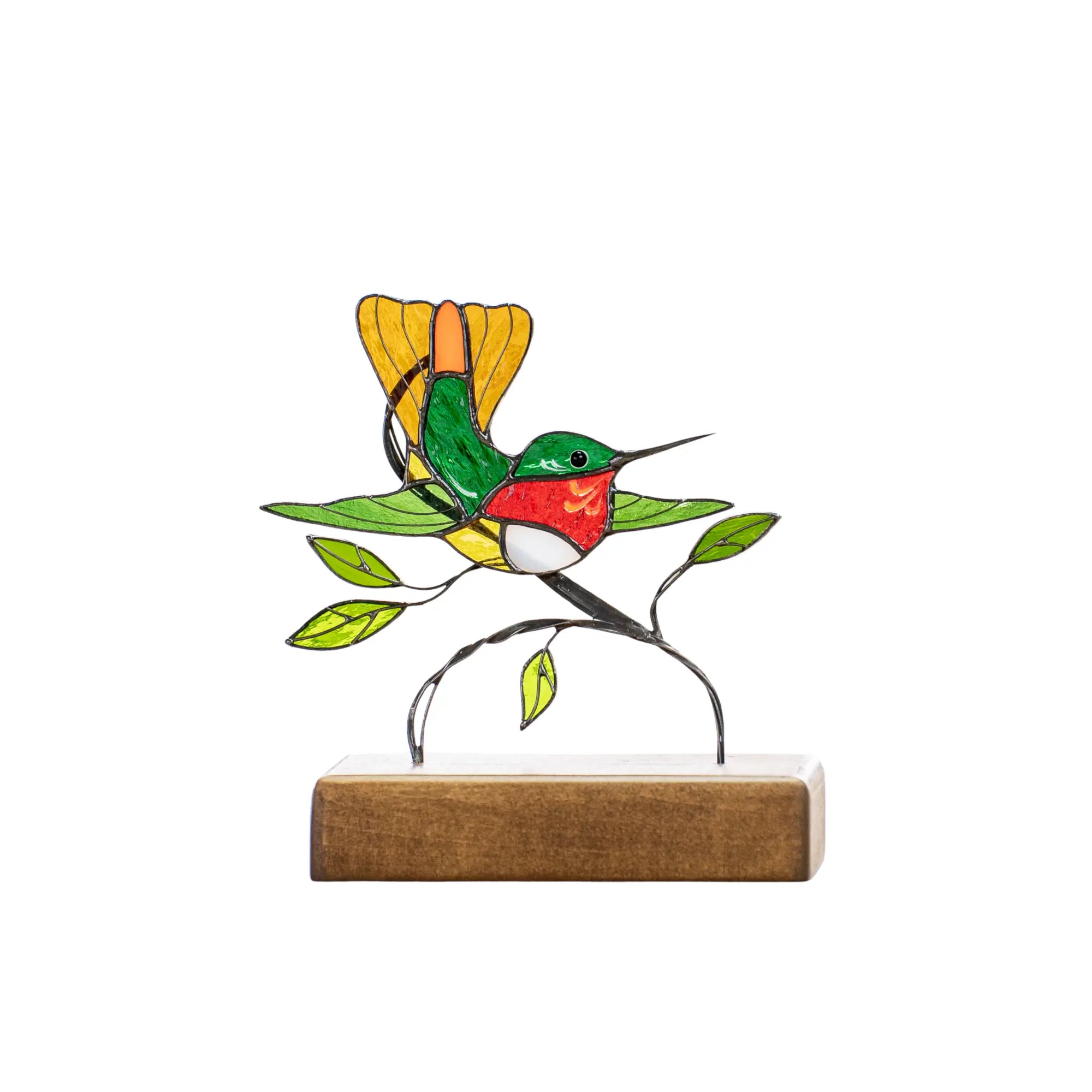 Stained glass hummingbird with curved beak and yellow-green wings, fixed in flying pose above branch.