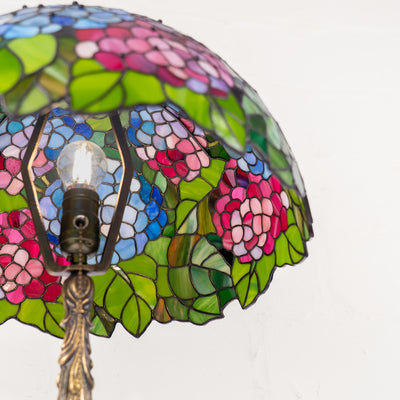 Inside look at Tiffany-style lamp with bulb and detailed glass flowers.