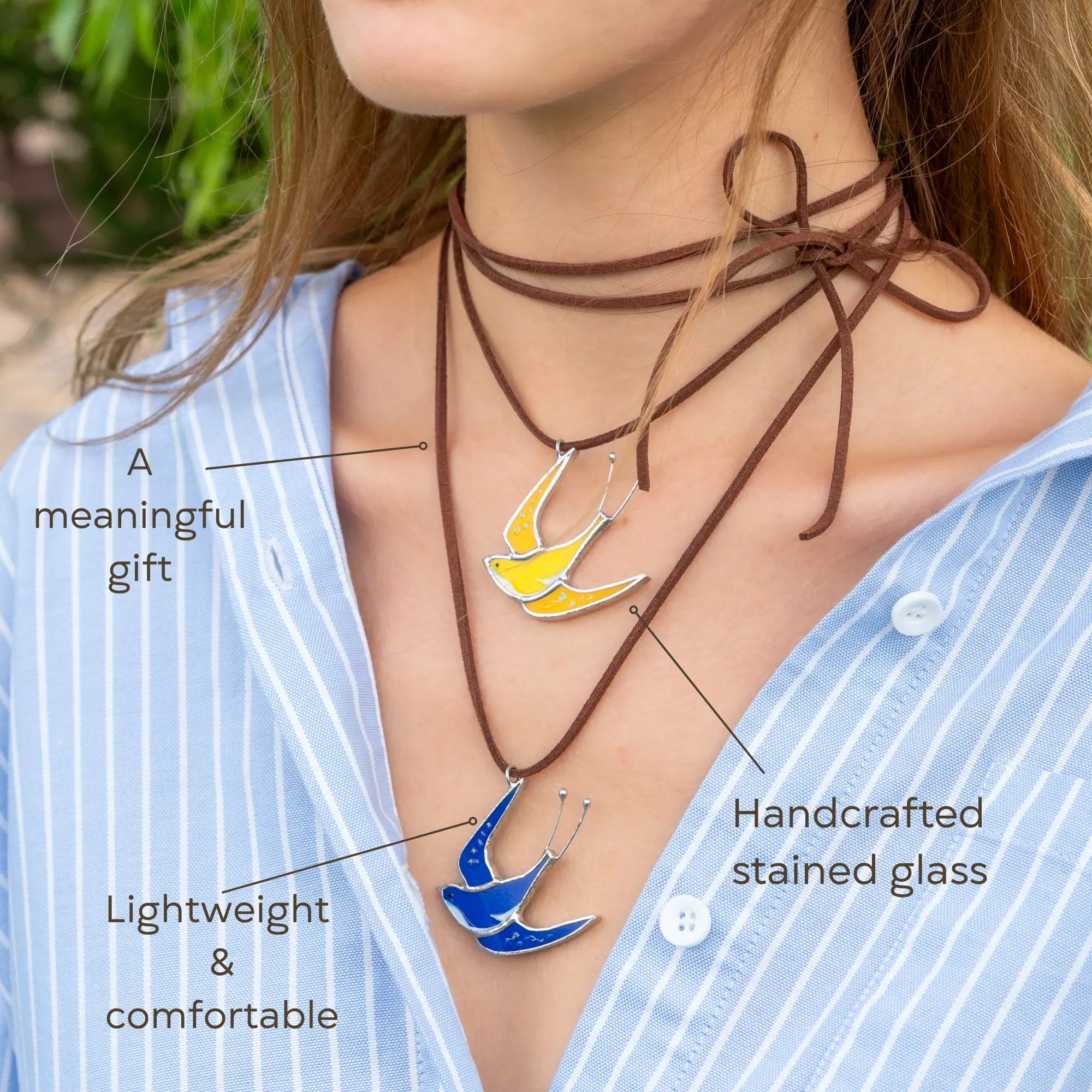 Person wearing a necklace with handcrafted stained glass swallow pendants - a meaningful gift for her.