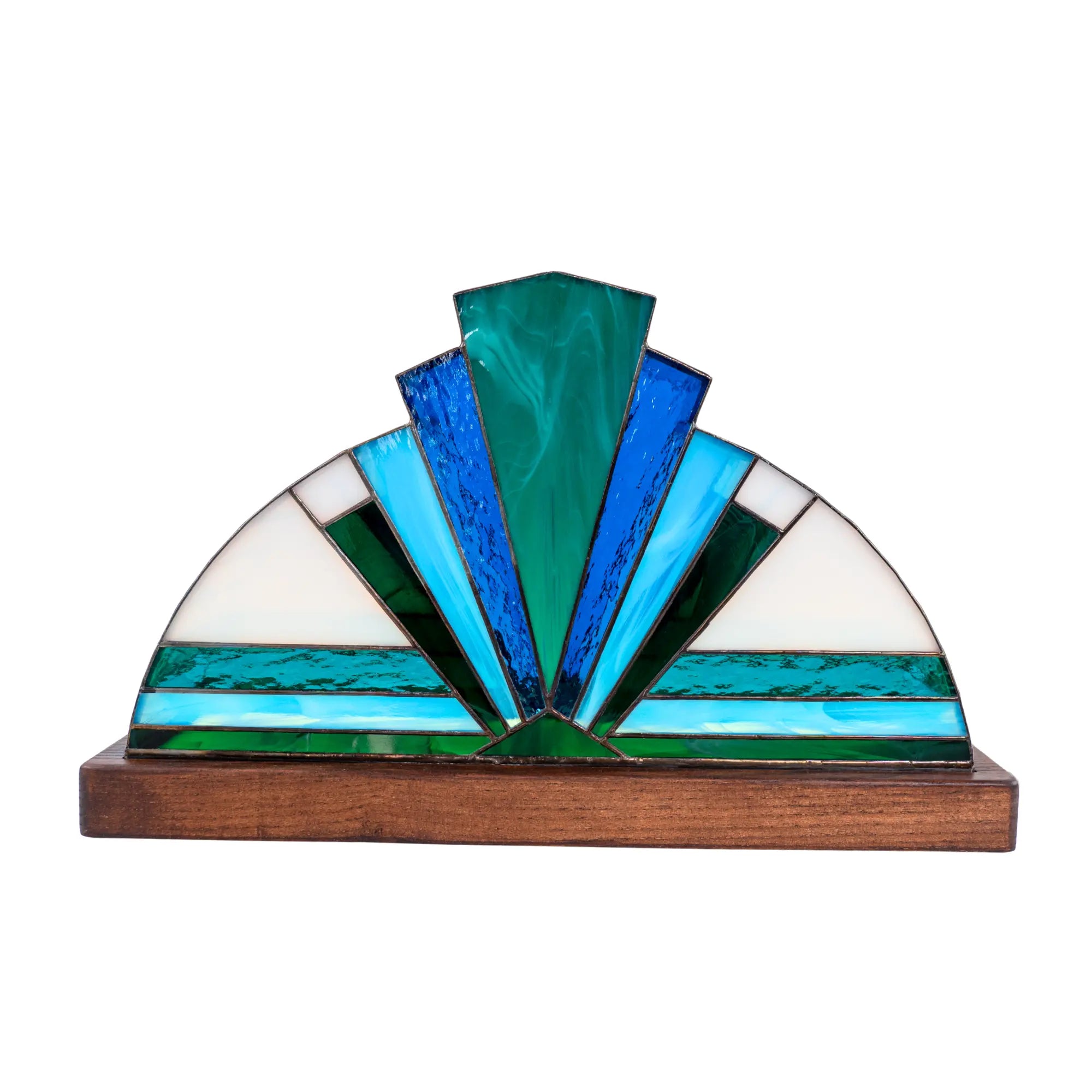Decorative stained glass piece with blue and green colors on a wooden base.