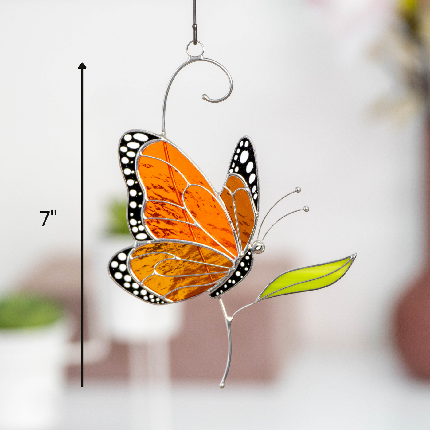 Stained glass butterfly side view hanging decor with size guide showing it's 7 inches height and modern background.