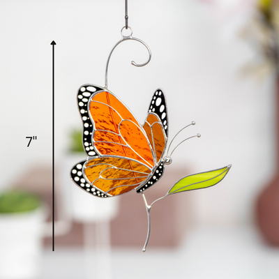 Stained glass butterfly side view hanging decor with size guide showing it's 7 inches height and modern background.