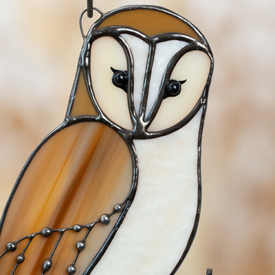Close-up of stained glass owl’s face with heart-shaped facial outline and black glass eyes