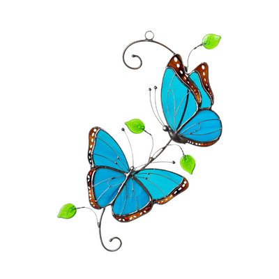Two vibrant blue morpho stained glass butterflies with brown-bordered wings and green glass leaves, hanging.