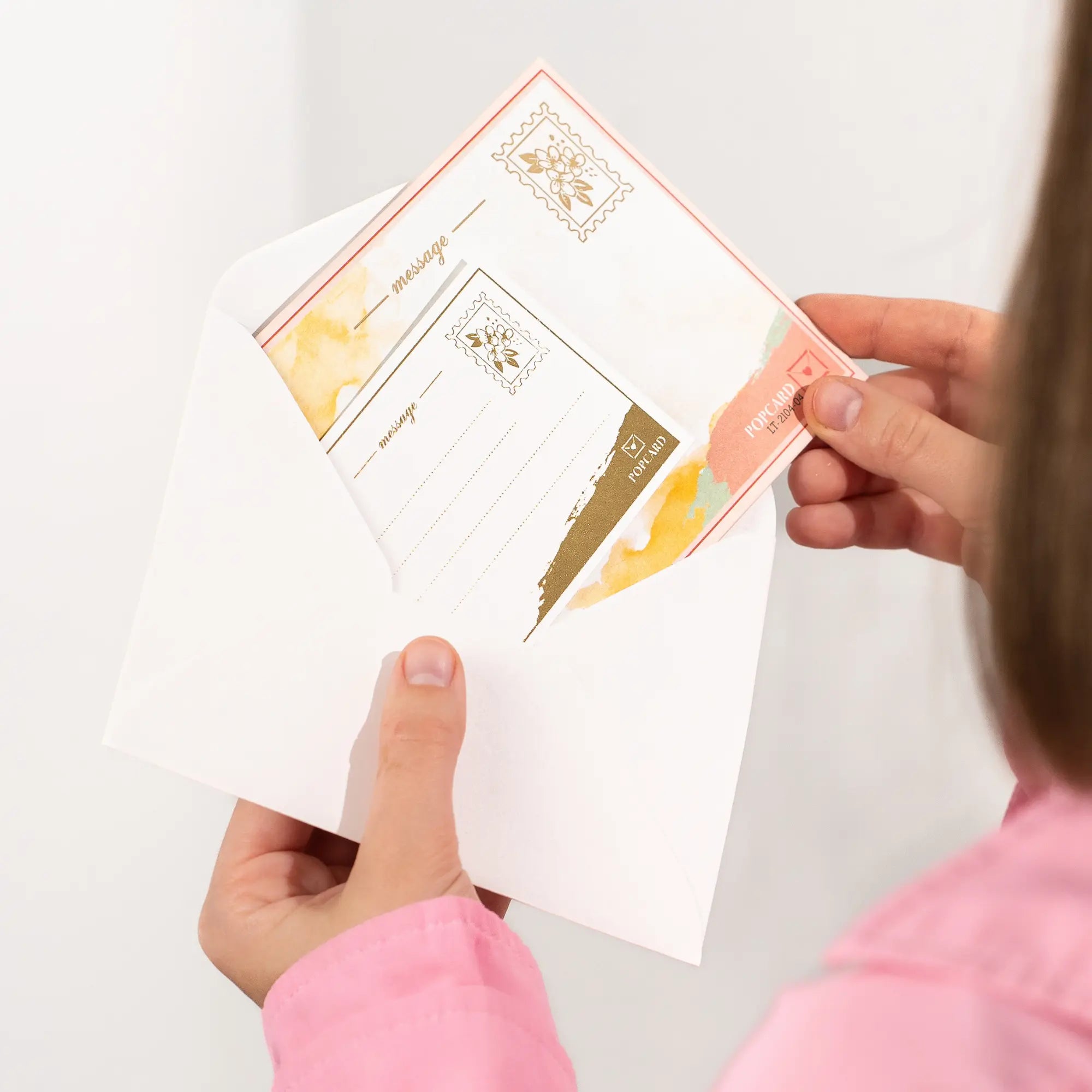 Hands holding a set of envelope and  greeting card with a white background