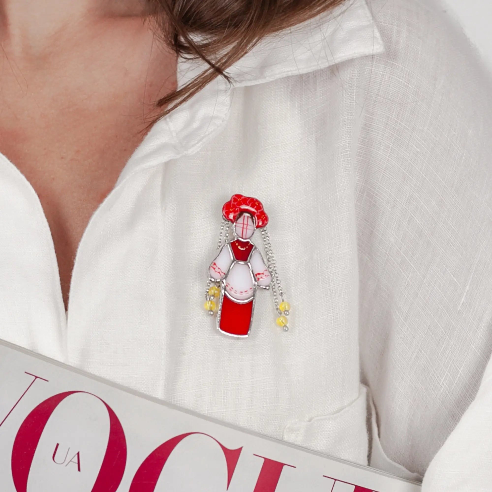 Person wearing a shirt with stained glass ukrainian traditional guardian brooch