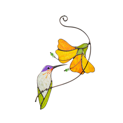 Glass cutting tools and pieces beside completed stained glass hummingbird and orange flower