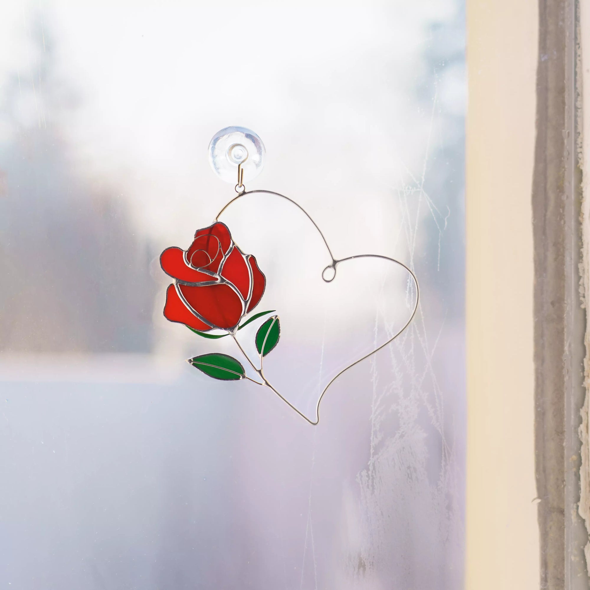 Rose heart stained glass suncatcher displayed on a window using a suction cup.
