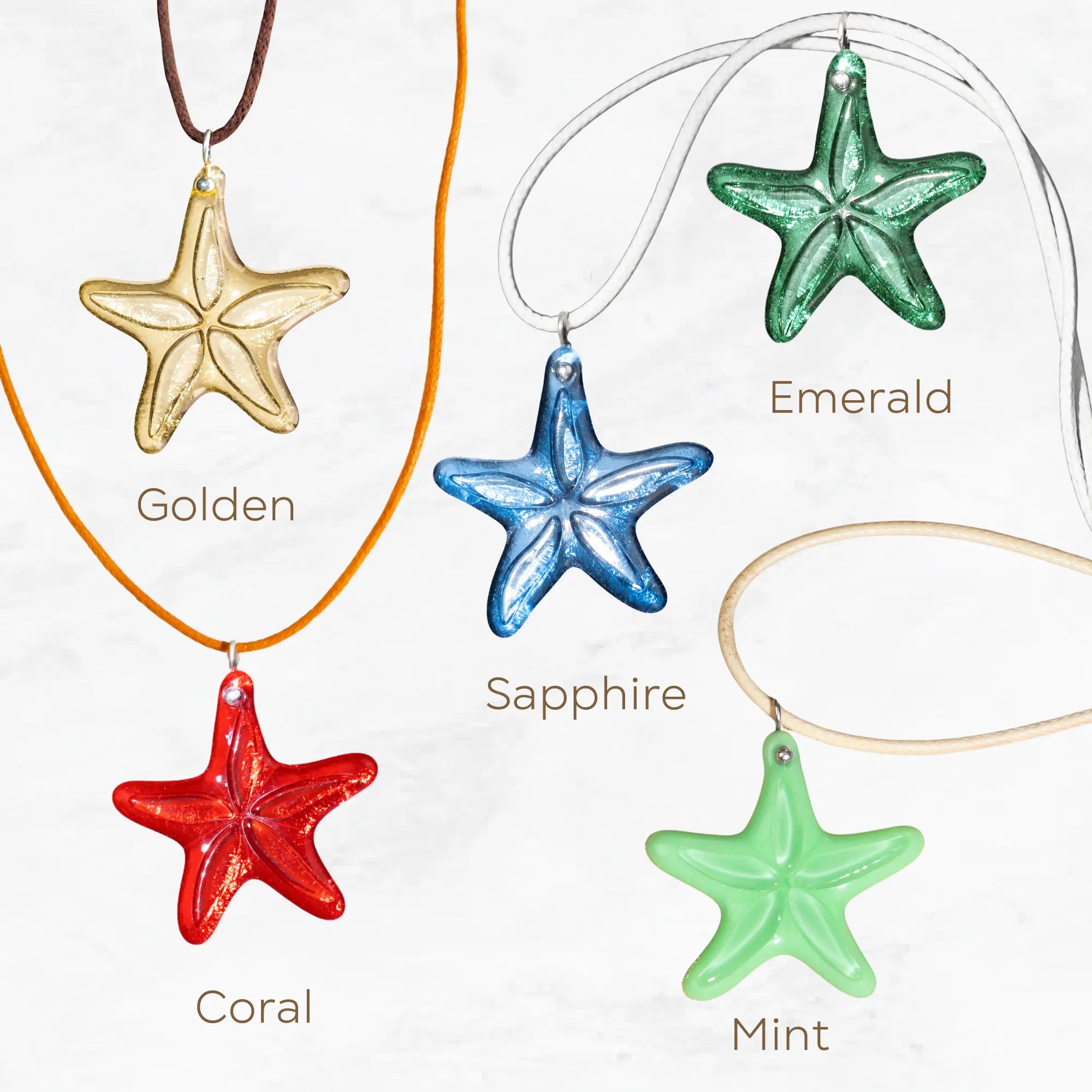 Collection of starfish pendants in different colors with names: Golden, Coral, Mint, Sapphire, Emerald on textured background.