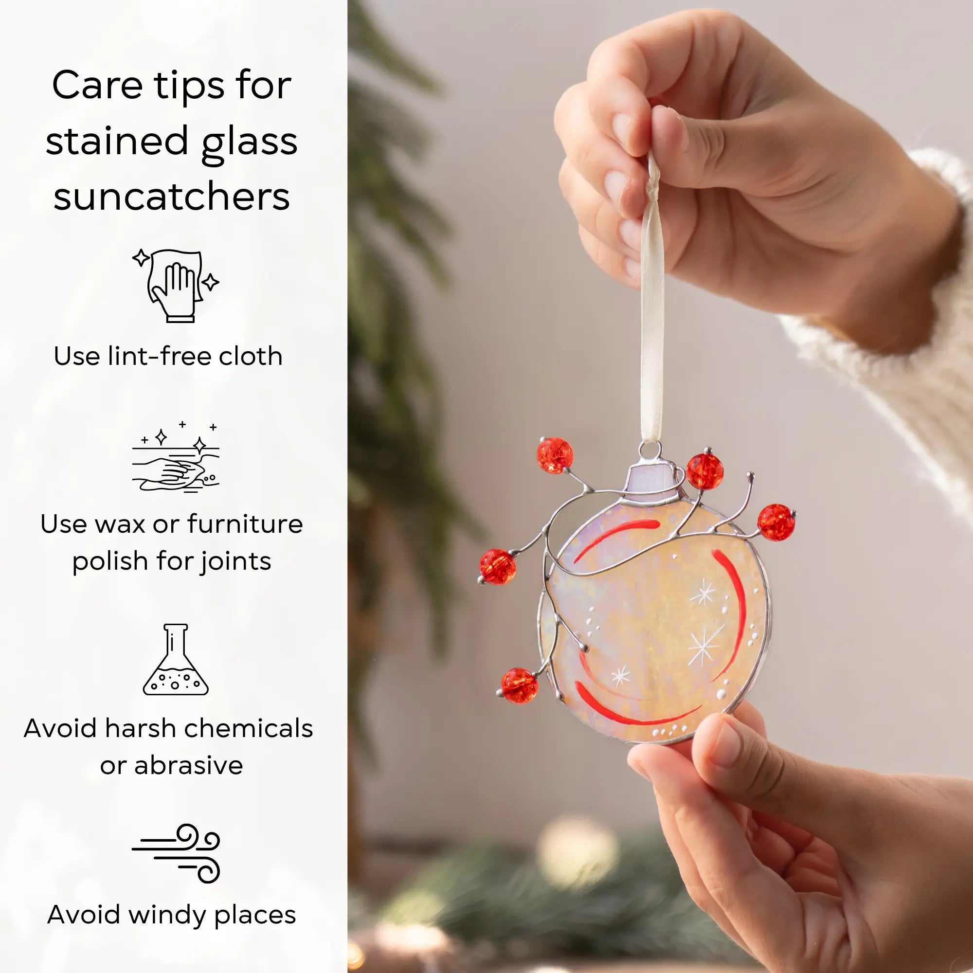 Stained glass Christmas ball suncatcher with sparkling white details and red berries, with care tips beside: use lint-free cloth, polish joints with car wax or furniture polish, avoid harsh chemicals, and windy places.