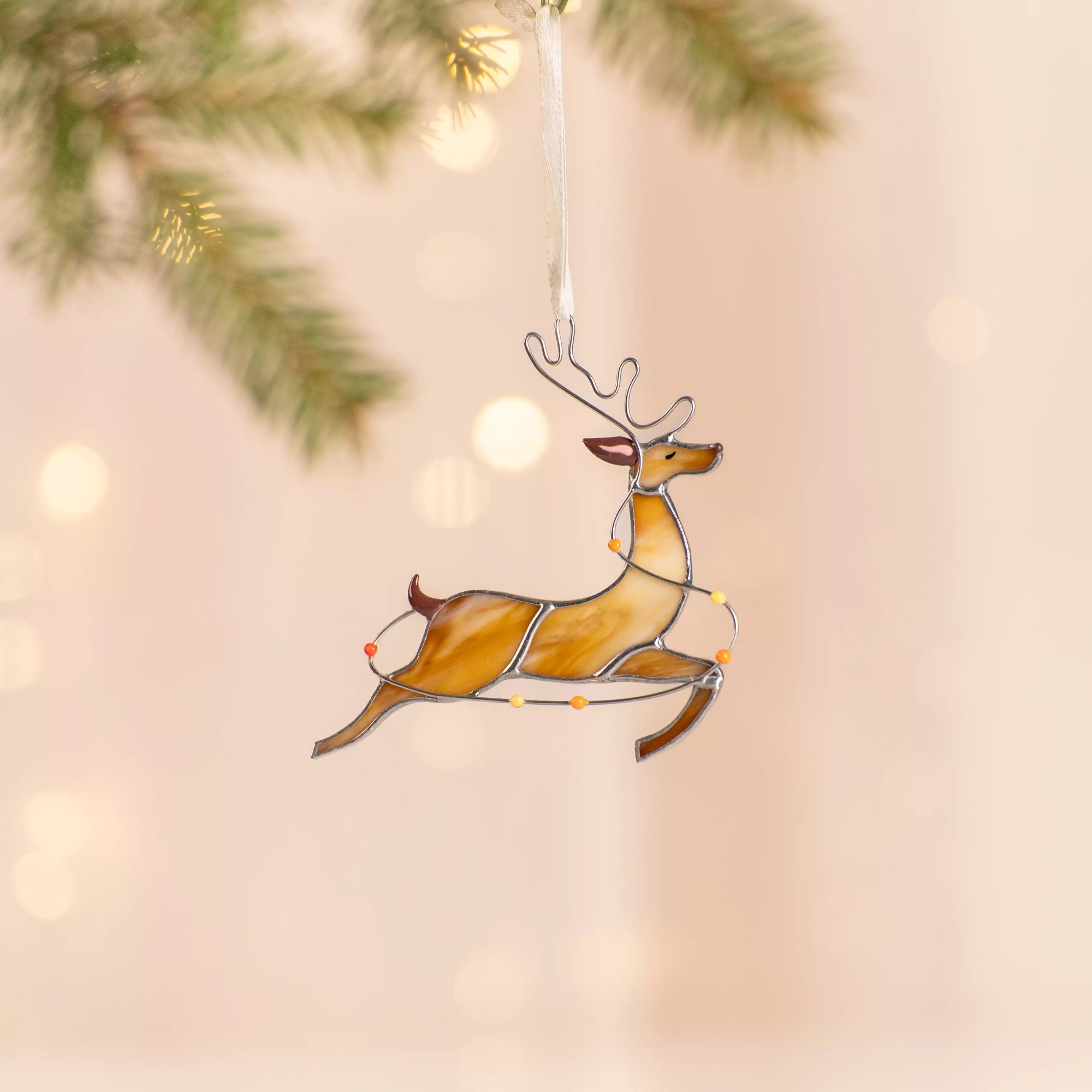 Stained glass reindeer with lights and a ribbon, running with vibrant holiday accents