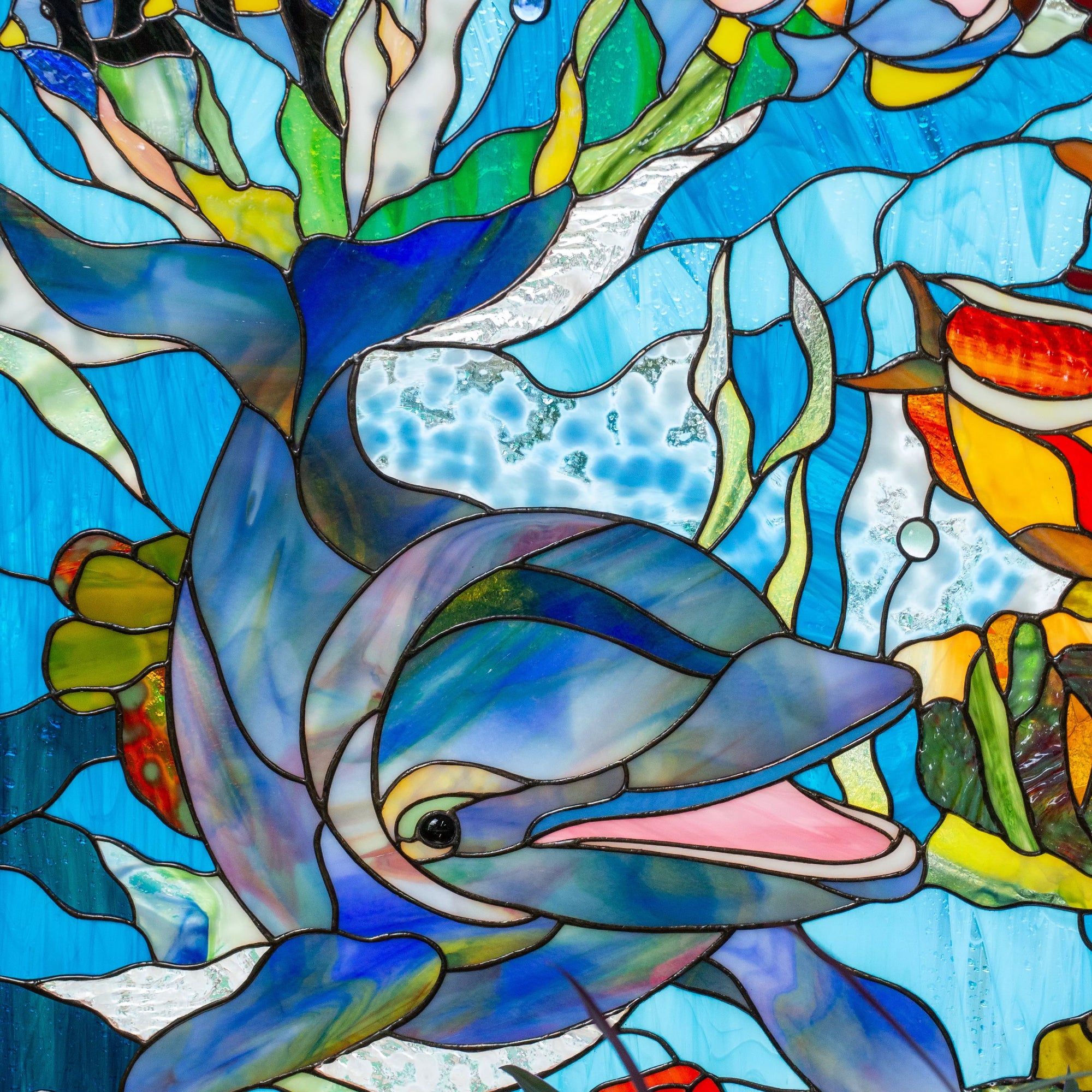 Custom stained glass panel of a dolphin and fish in an underwater scene