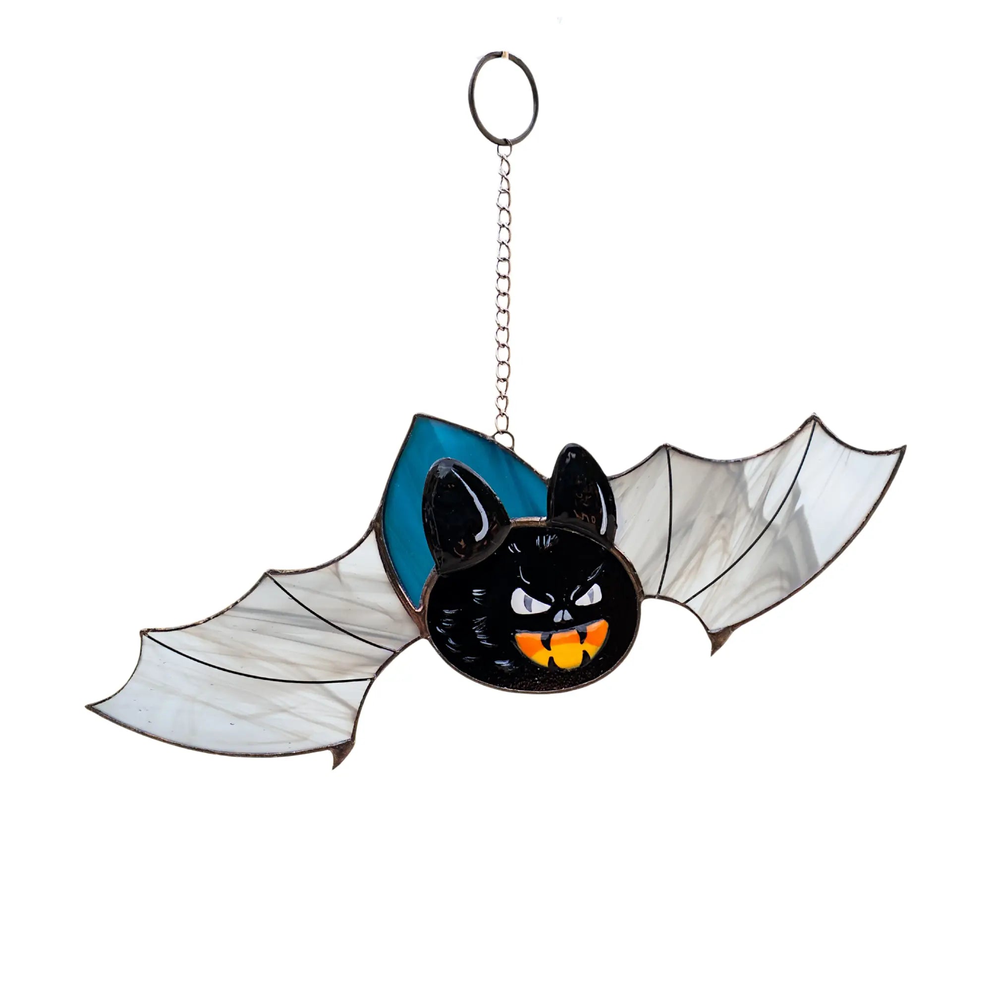 Stained glass bat with white wings, blue background, and orange pumpkin-orange fangs