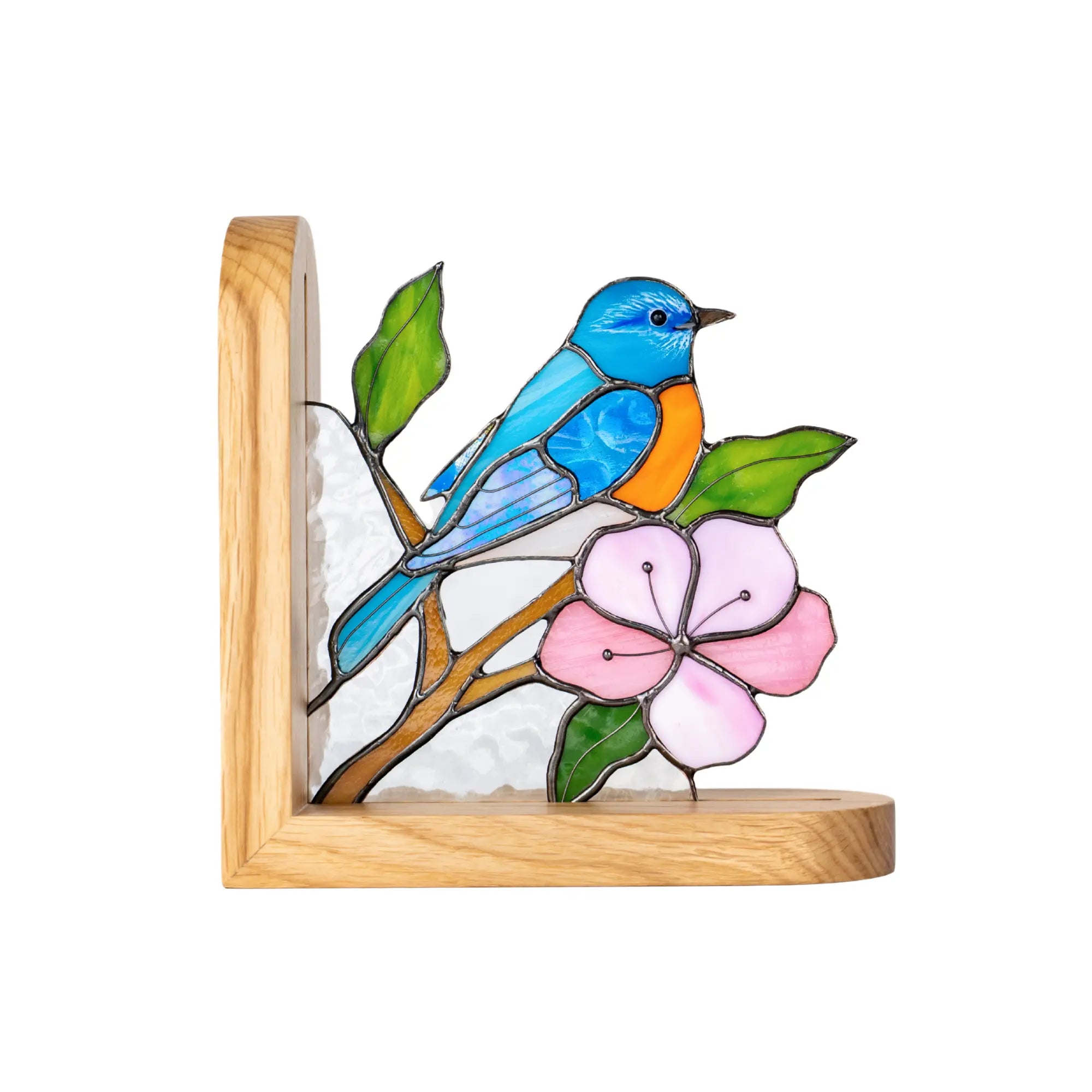 Stained glass bookend with bluebird on a branch with pink flowers in a wooden frame.