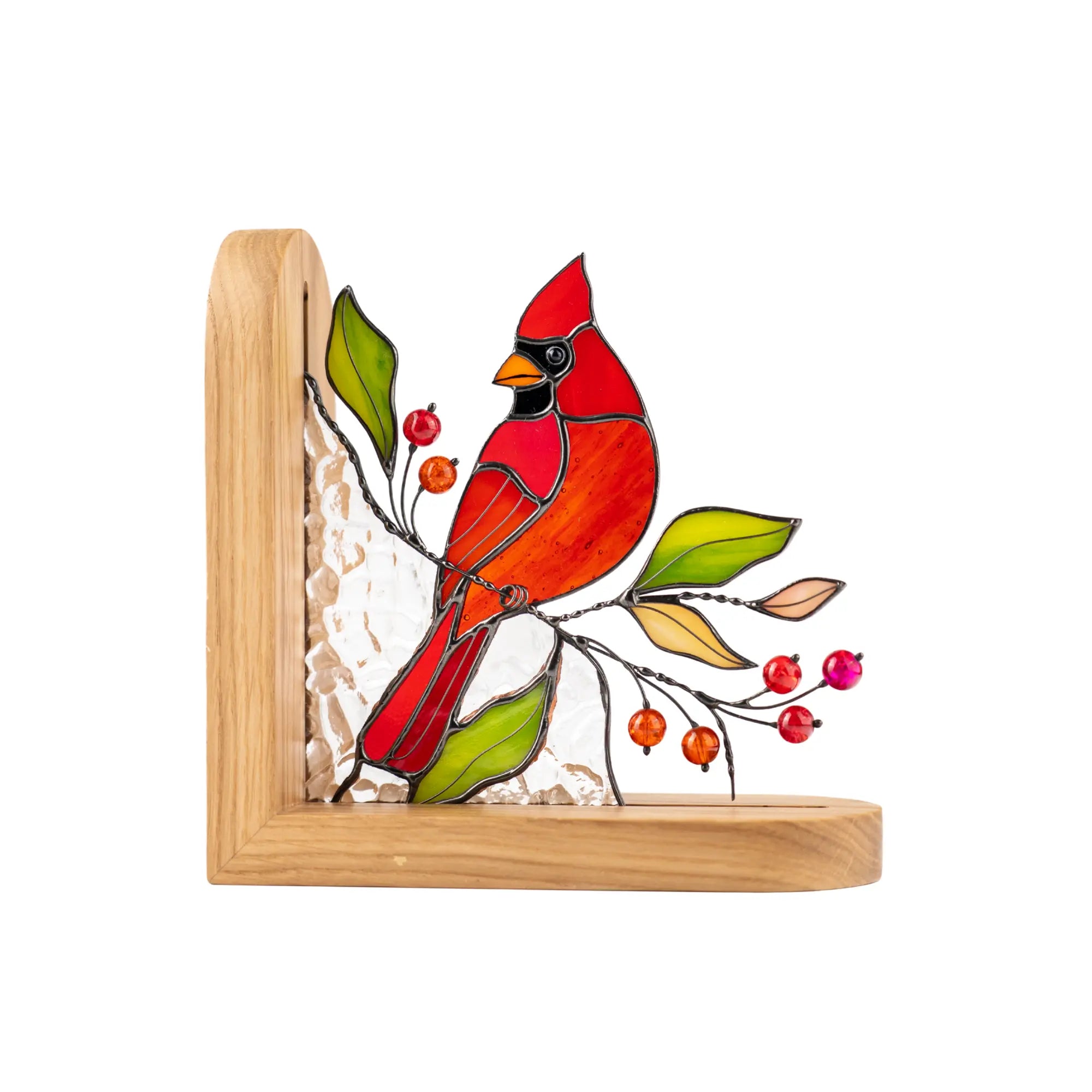 Stained glass cardinal bird perched on a branch with red beads and green leaves in a wooden bookend frame.