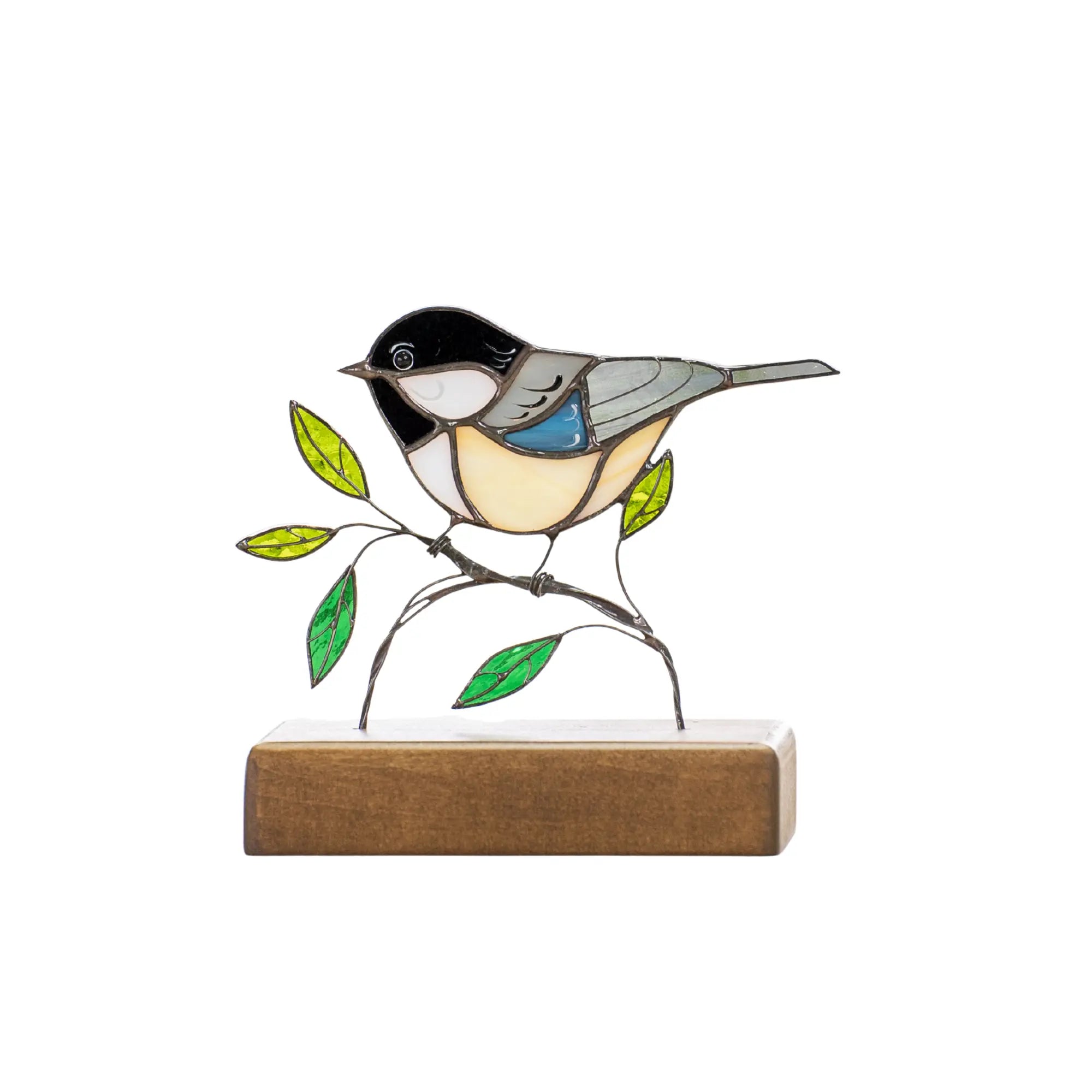 Stained glass chickadee perched on leafy branch with dark wood stand