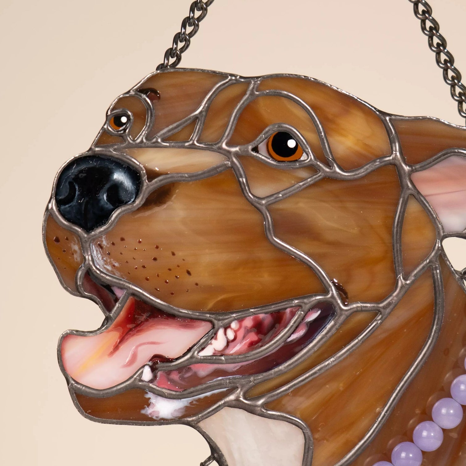 Stained glass suncatcher pet portrait of dog with a chain and beads on a beige background