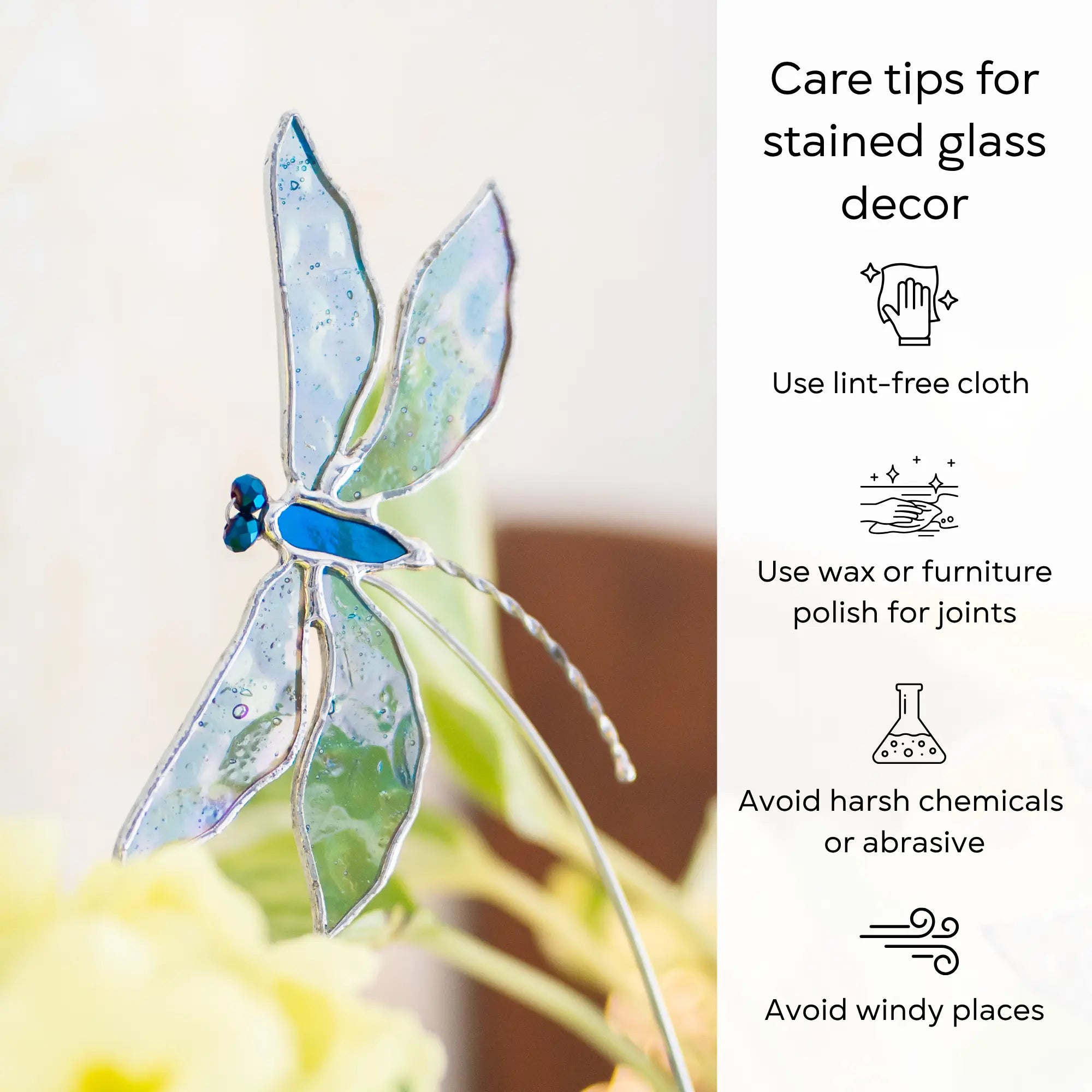 Stained glass dragonfly plant stake with care tips on a blurred background: use lint-free cloth, polish joints with car wax or furniture polish, avoid harsh chemicals, and windy places.