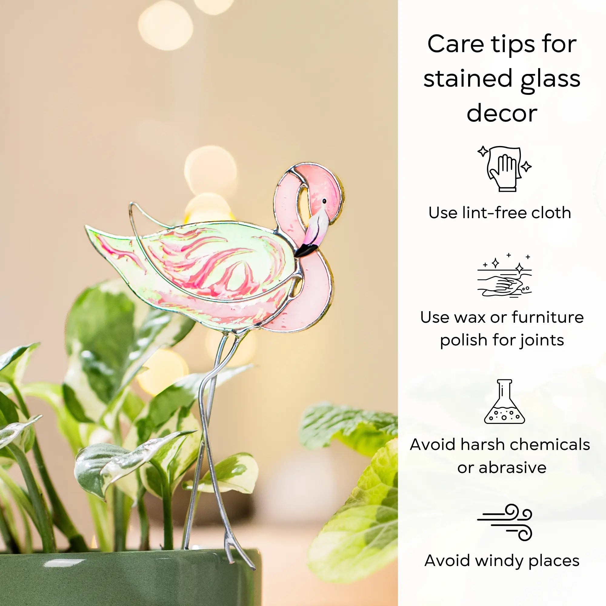 Stained glass flamingo plant stake with care tips on a blurred background: use lint-free cloth, polish joints with car wax or furniture polish, avoid harsh chemicals, and windy places.
