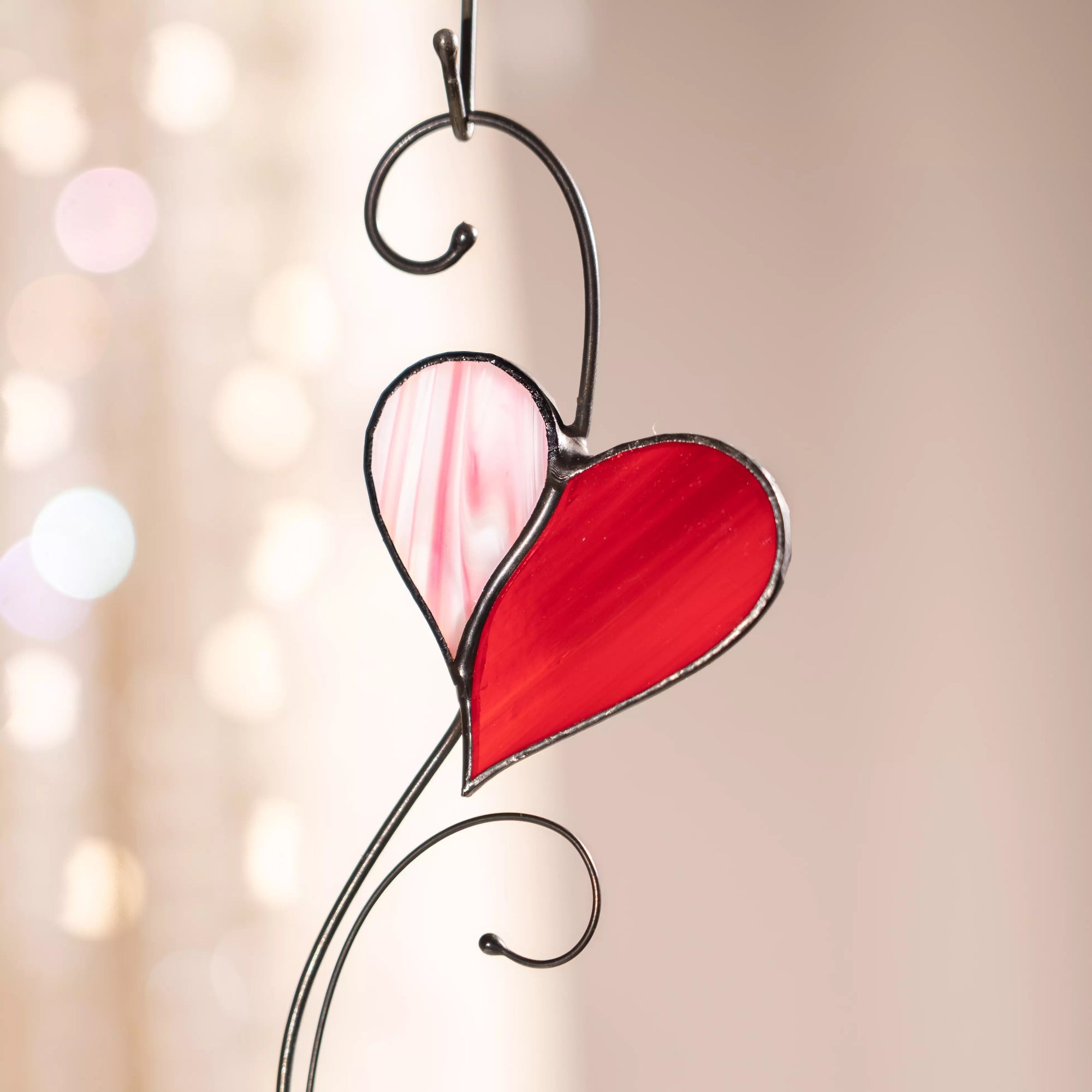 Stained glass heart detail with pink and red colors on a blurred background