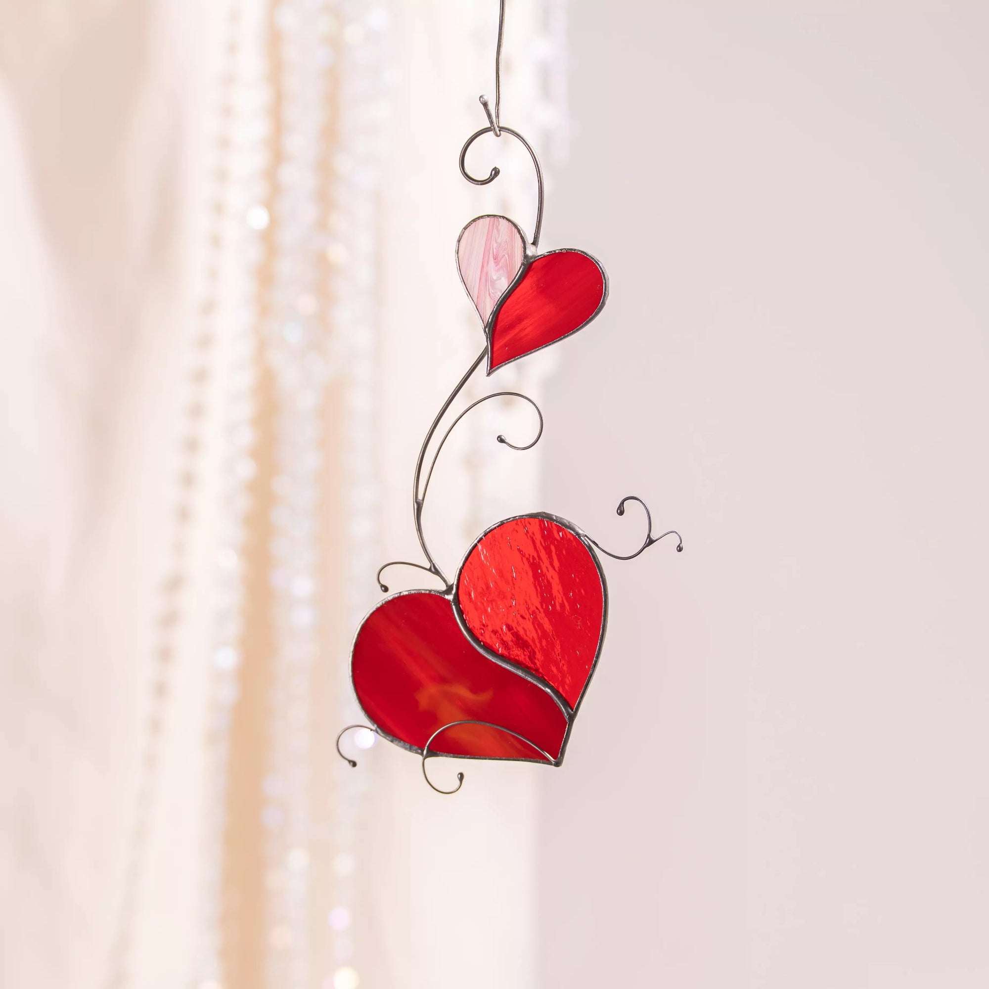 Stained glass suncatcher featuring two red hearts