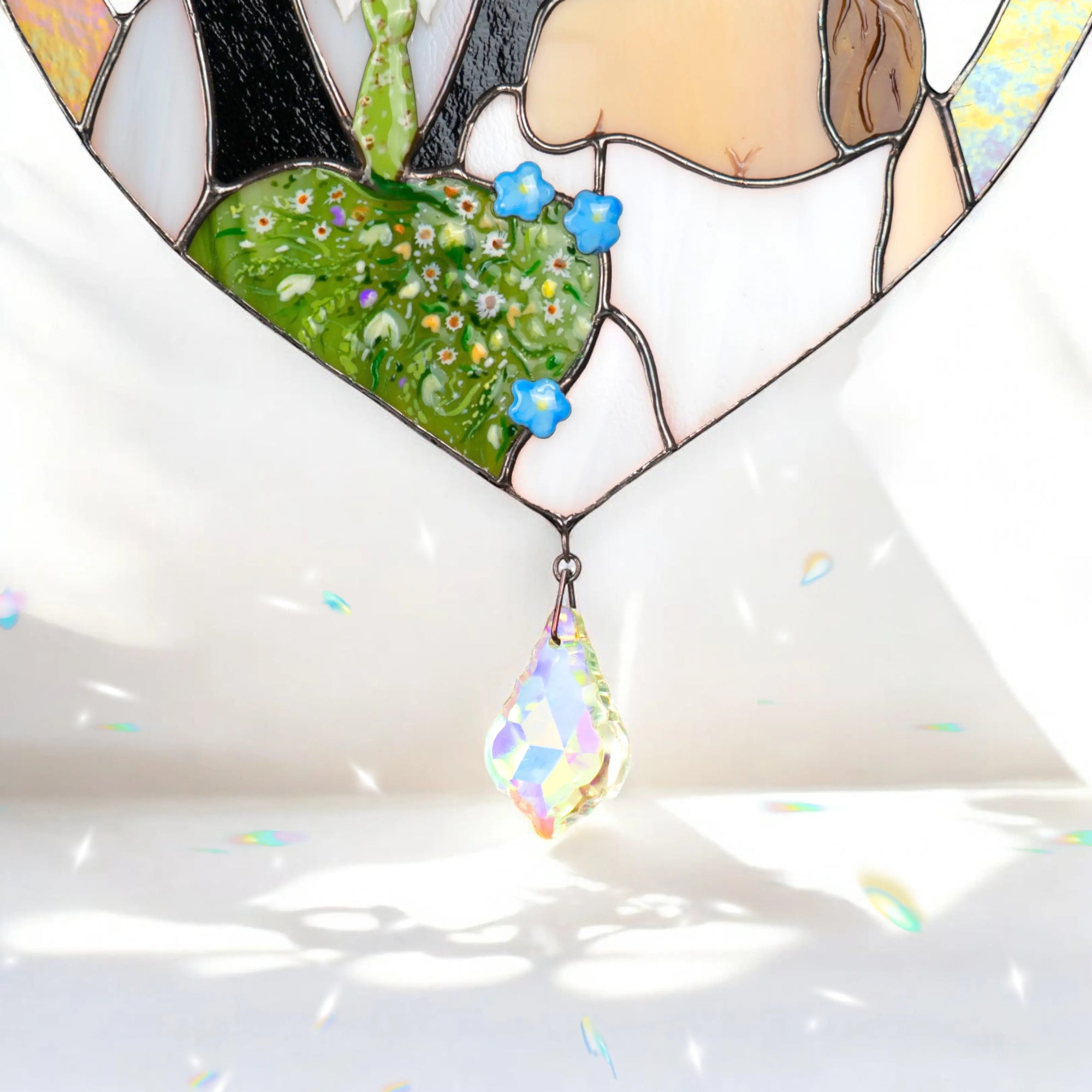 Iridescent stained glass heart with floral design and rainbow teardrop on a white background
