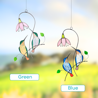 Two stained glass suncatchers featuring hummingbird pairs in green and blue, each near a pink flower.