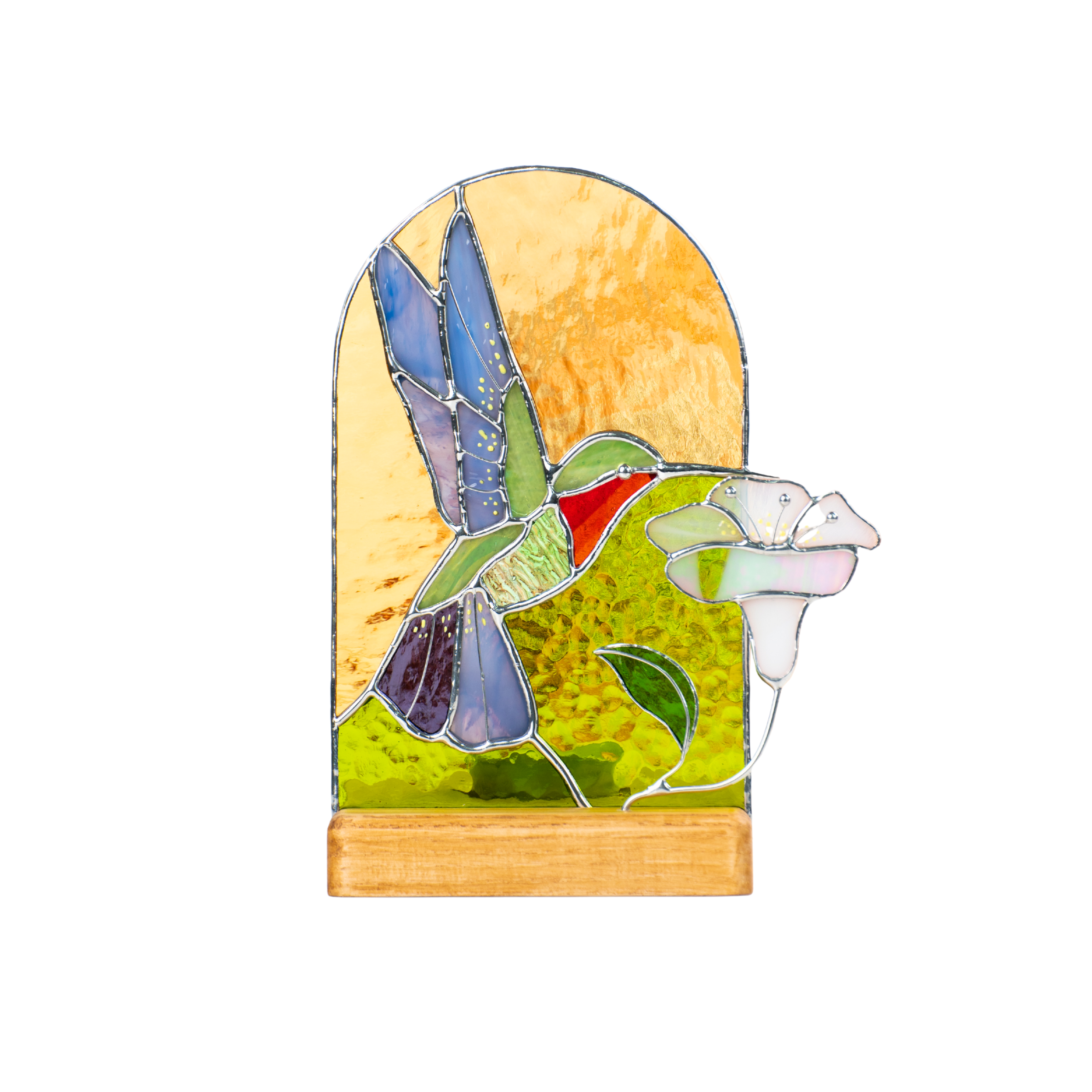 Colorful stained glass hummingbird with a white flower, set in a golden arched panel with a wooden stand.