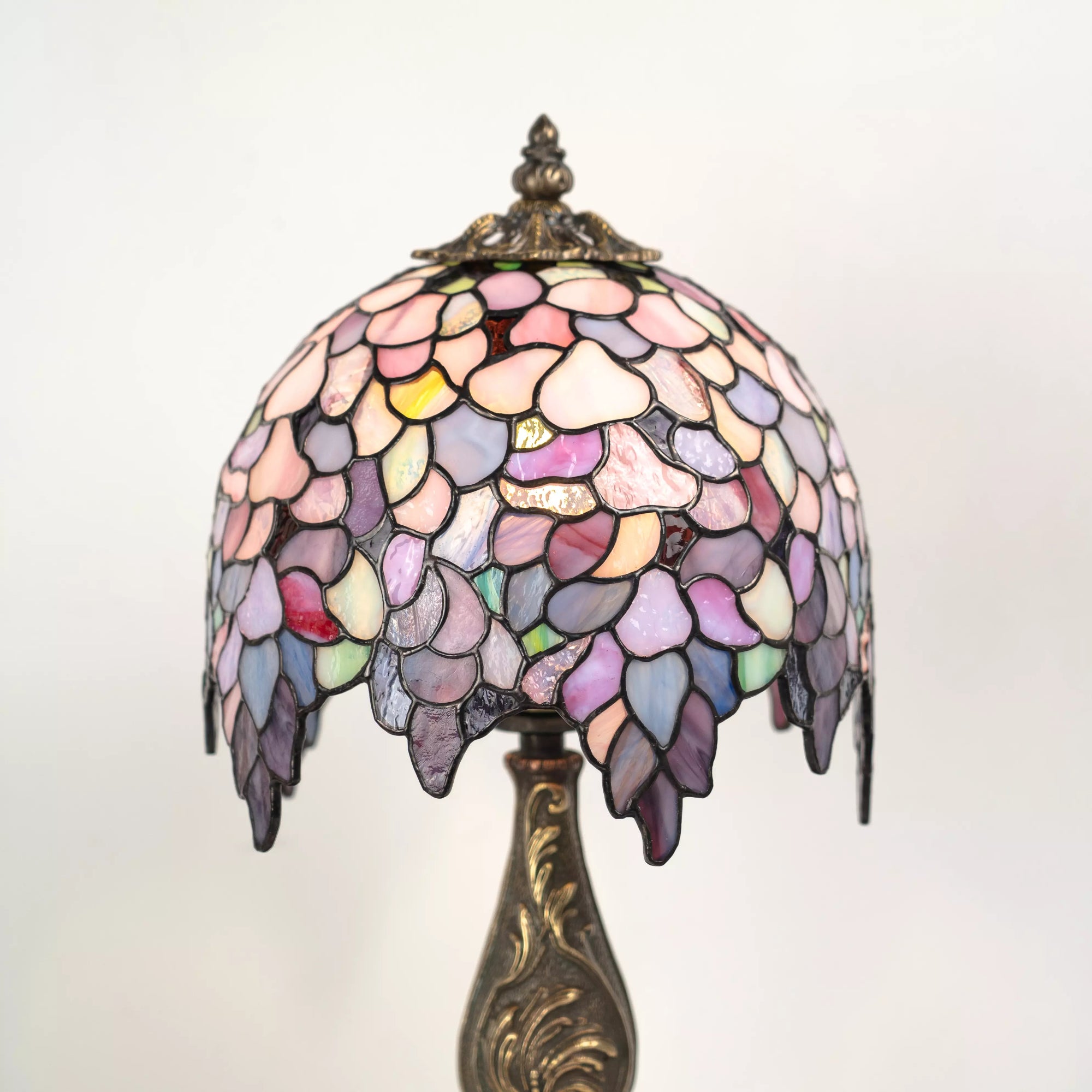 Stained glass Tiffany Wisteria lamp with a colorful shade on a white background