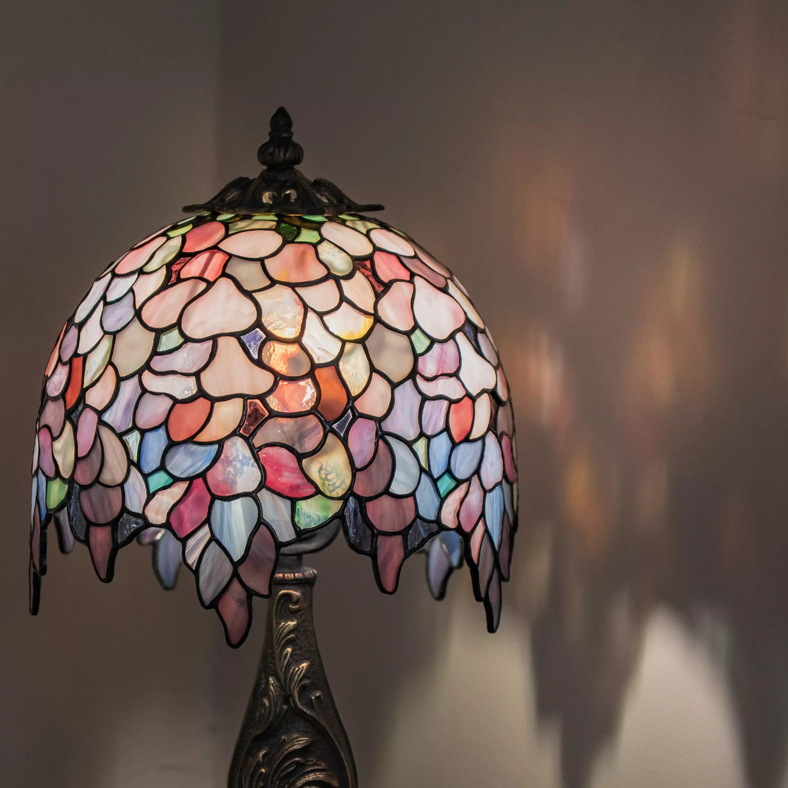 Stained glass lamp with a colorful shade casting a colorful shadow