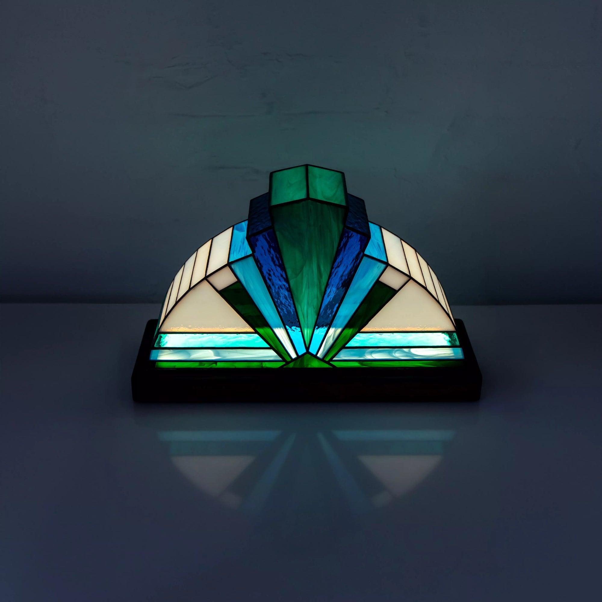Top view of blue stained glass lamp geometric glass shaded with teal and gray reflections.