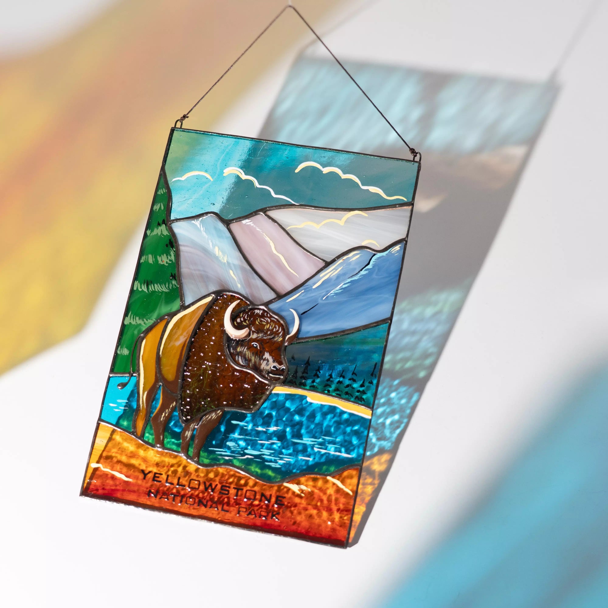 Stained glass panel with a buffalo and mountain design, featuring Yellowstone National Park text.