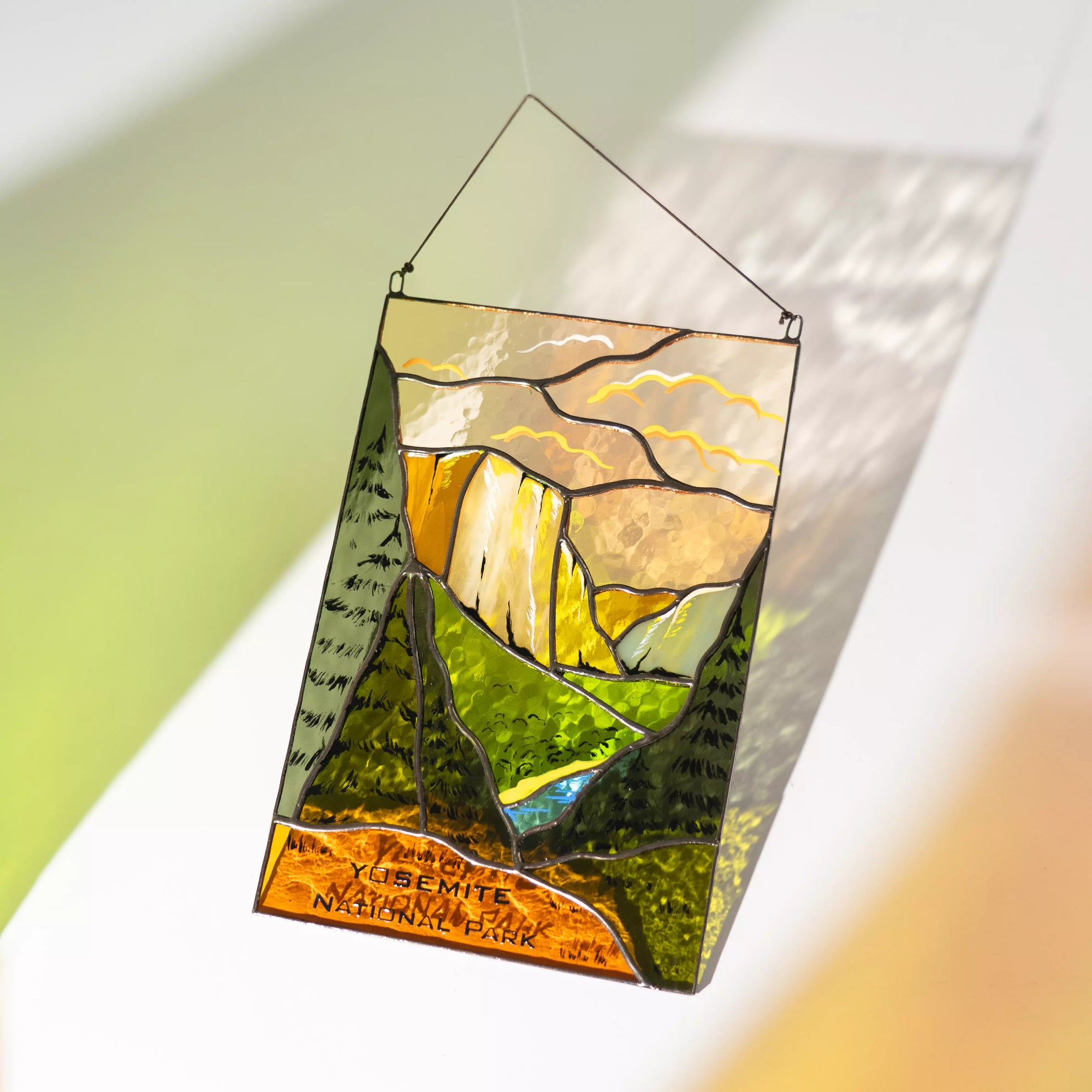 Stained glass panel of Yosemite National Park with hanging hook on a white background