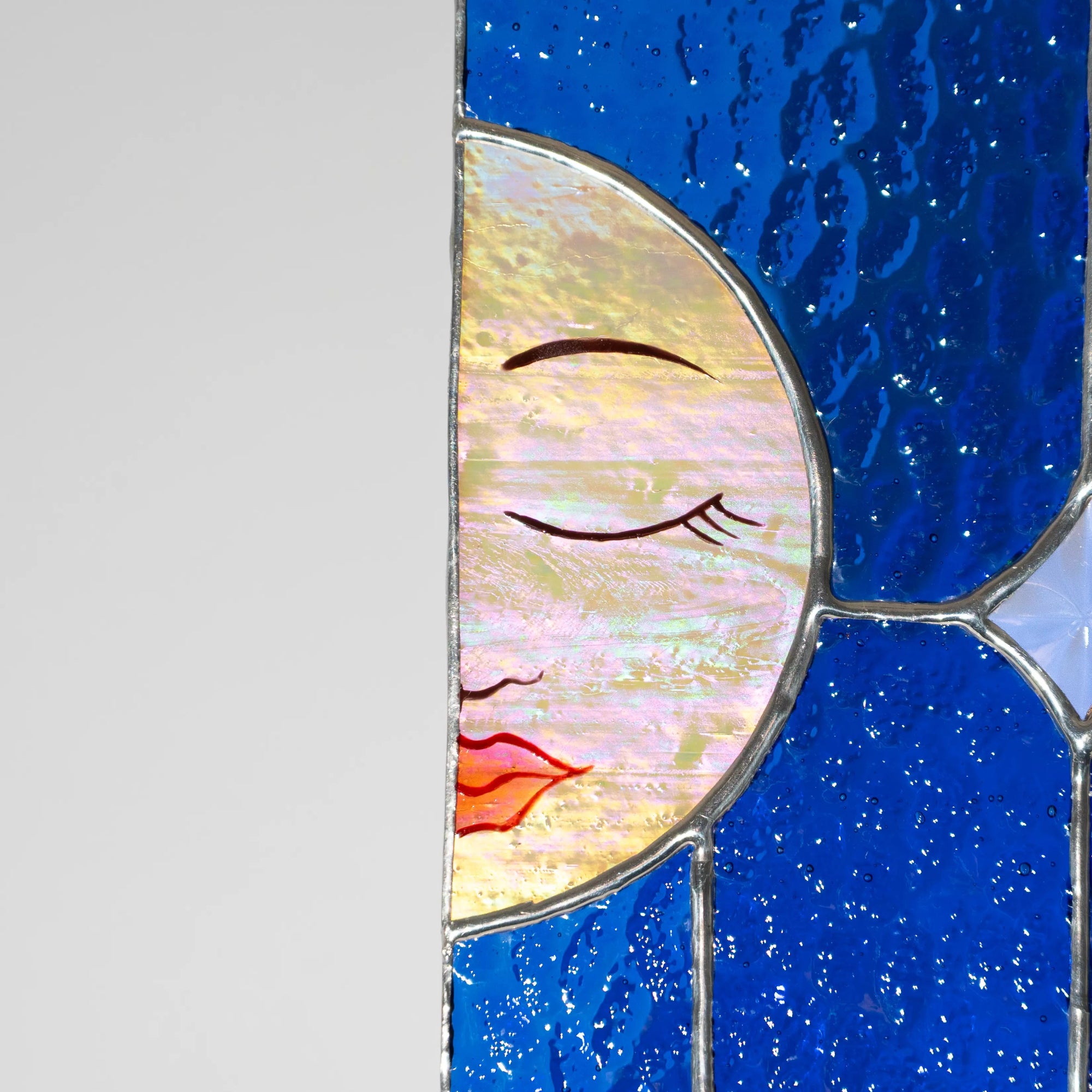 Stained glass panel with a moon design on a blue background