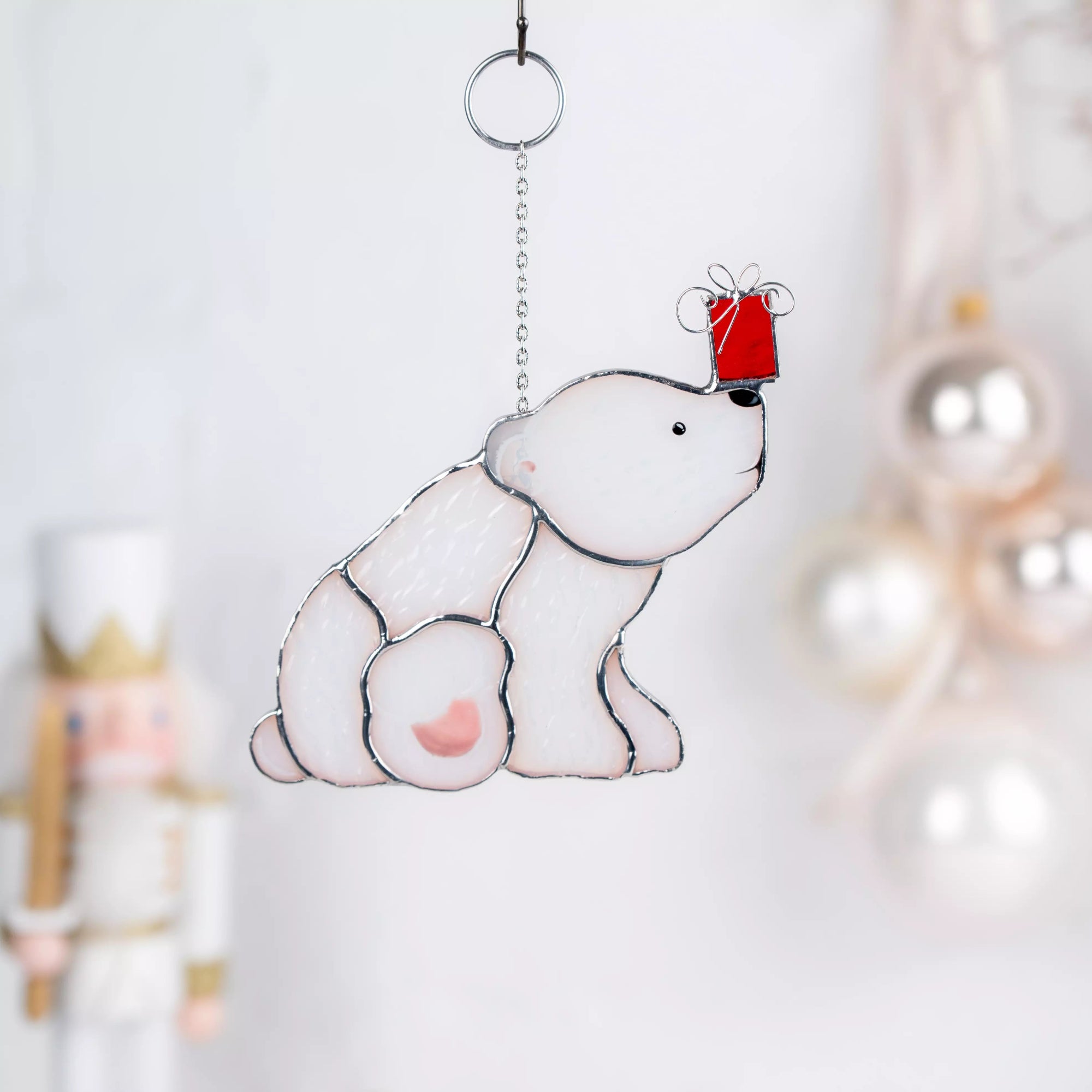 Decorative polar bear ornament with a red hat on a white background