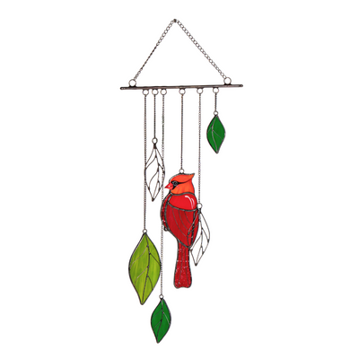 Red stained glass cardinal and bright green leaves hanging on a decorative wind chime.