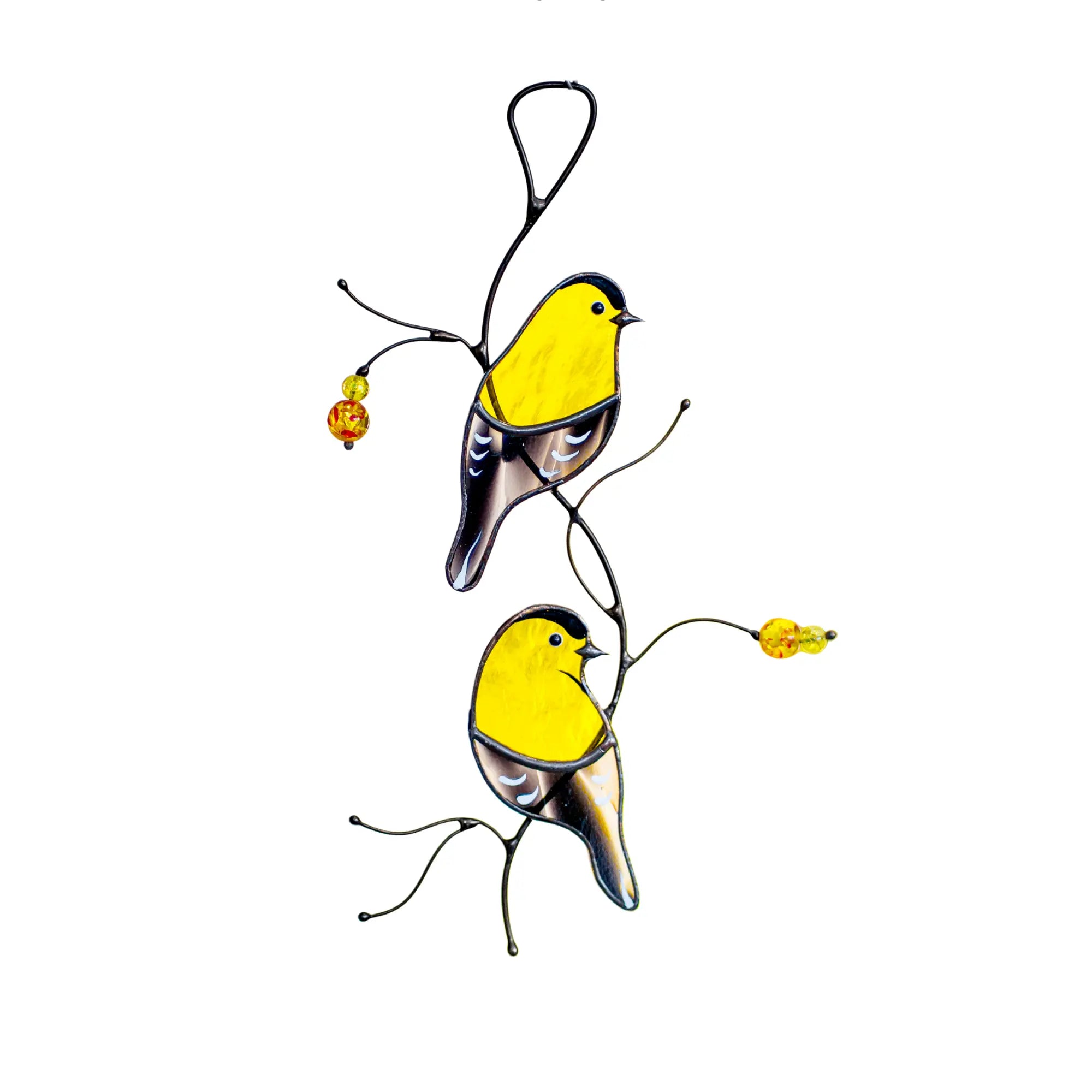 Two vibrant yellow and black stained glass goldfinches perched on artistic metal branches with amber beads, shown against a clean white background.
