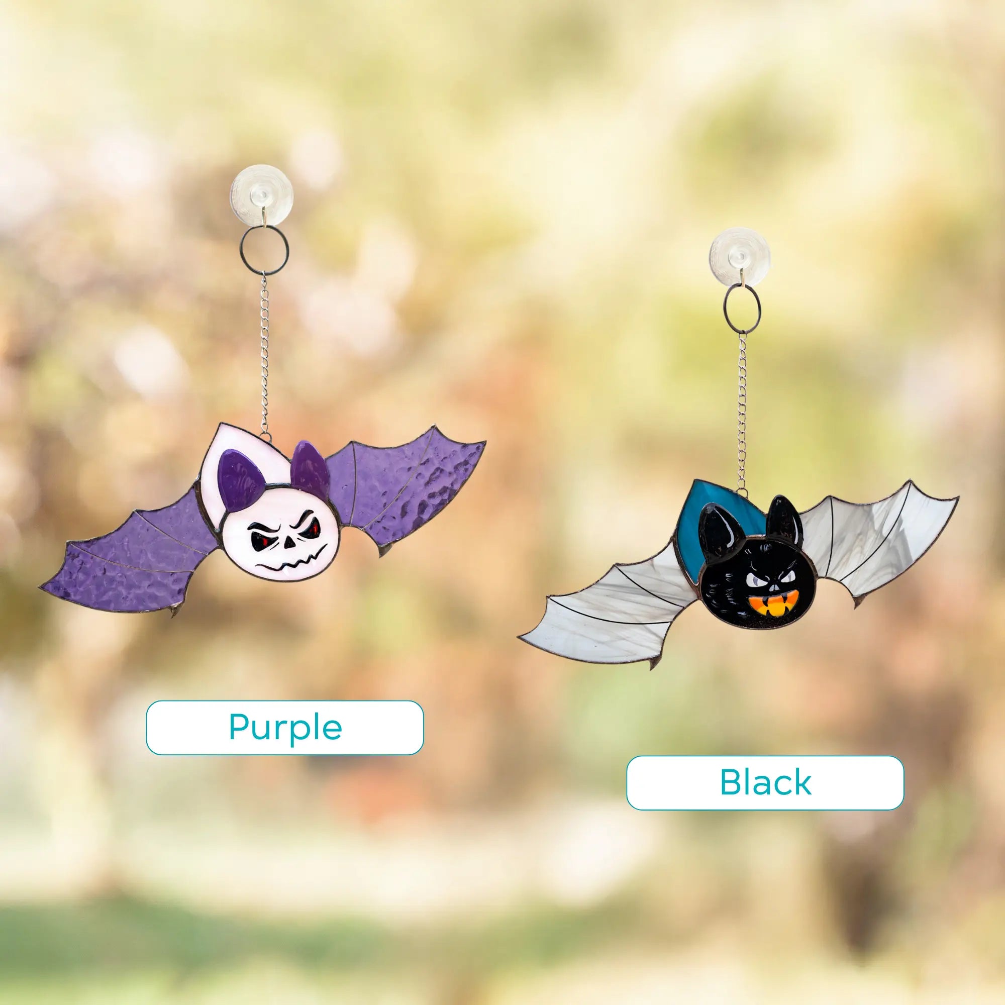 Variation of two halloween stained glass flying bat suncatchers: purple and black one