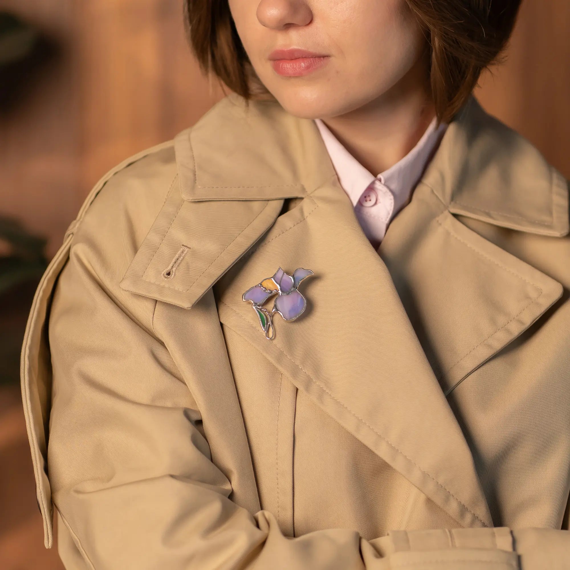 Women wearing a stained glass iris brooch on a blurred background
