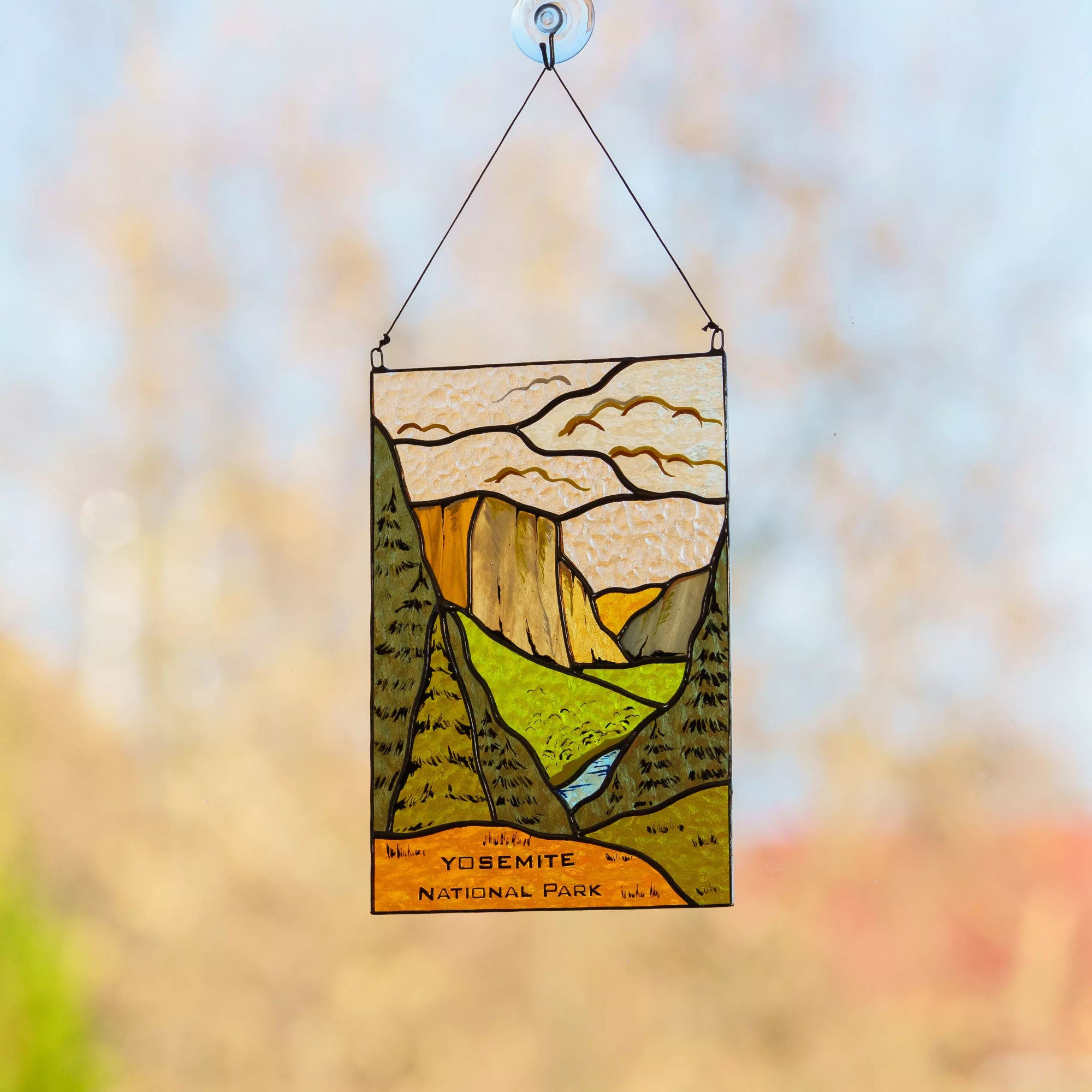 Stained glass panel of Yosemite National Park with a blurred natural background