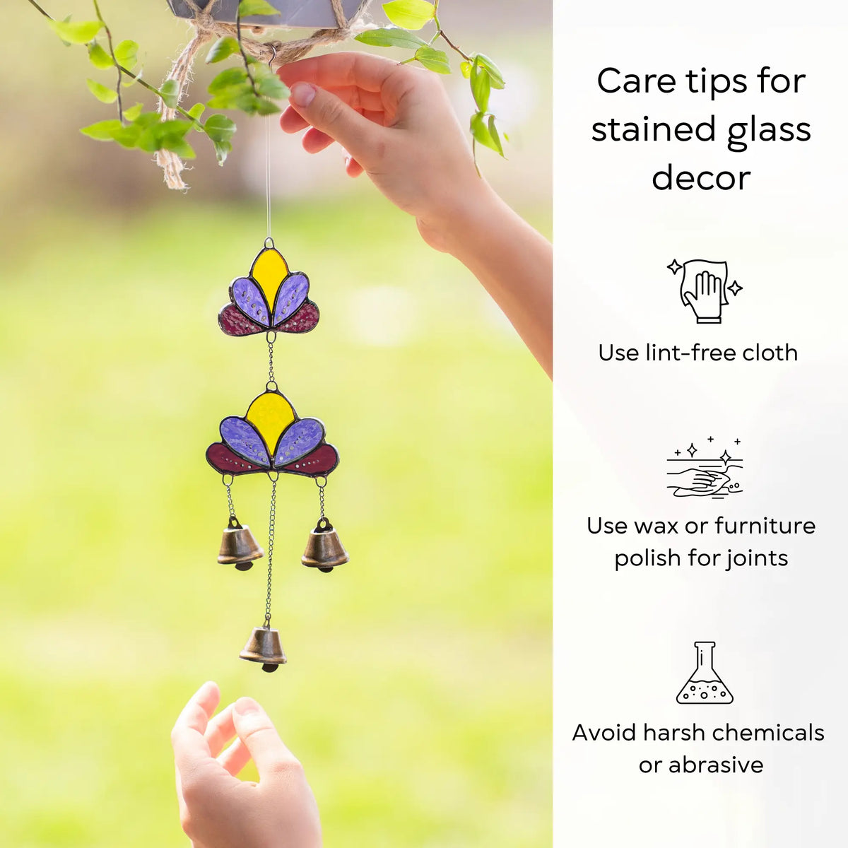 A person's hands demonstrating care tips for a lotus stained glass wind chime, including using a lint-free cloth and avoiding chemicals.