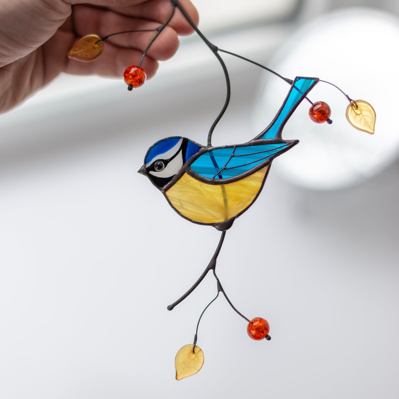 Blue stained glass chickadee sitting on the branch suncatcher
