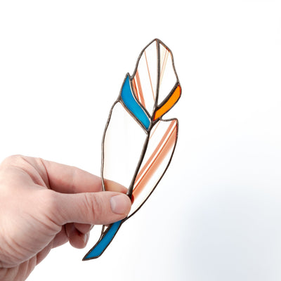 Stained glass clear feather with shades of orange and blue suncatcher